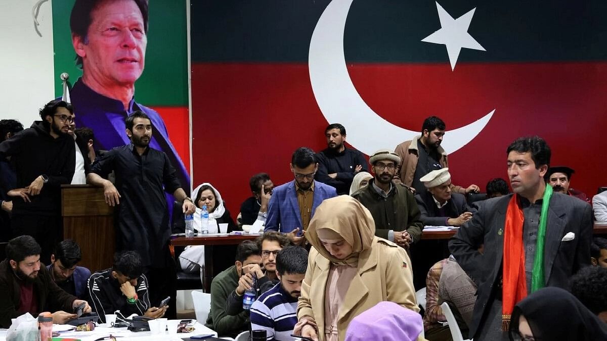 <div class="paragraphs"><p>Volunteers for former Prime Minister Imran Khan's party Pakistan Tehreek-e-Insaf (PTI) look on as they watch results on TV screens after the end of the polling.</p></div>