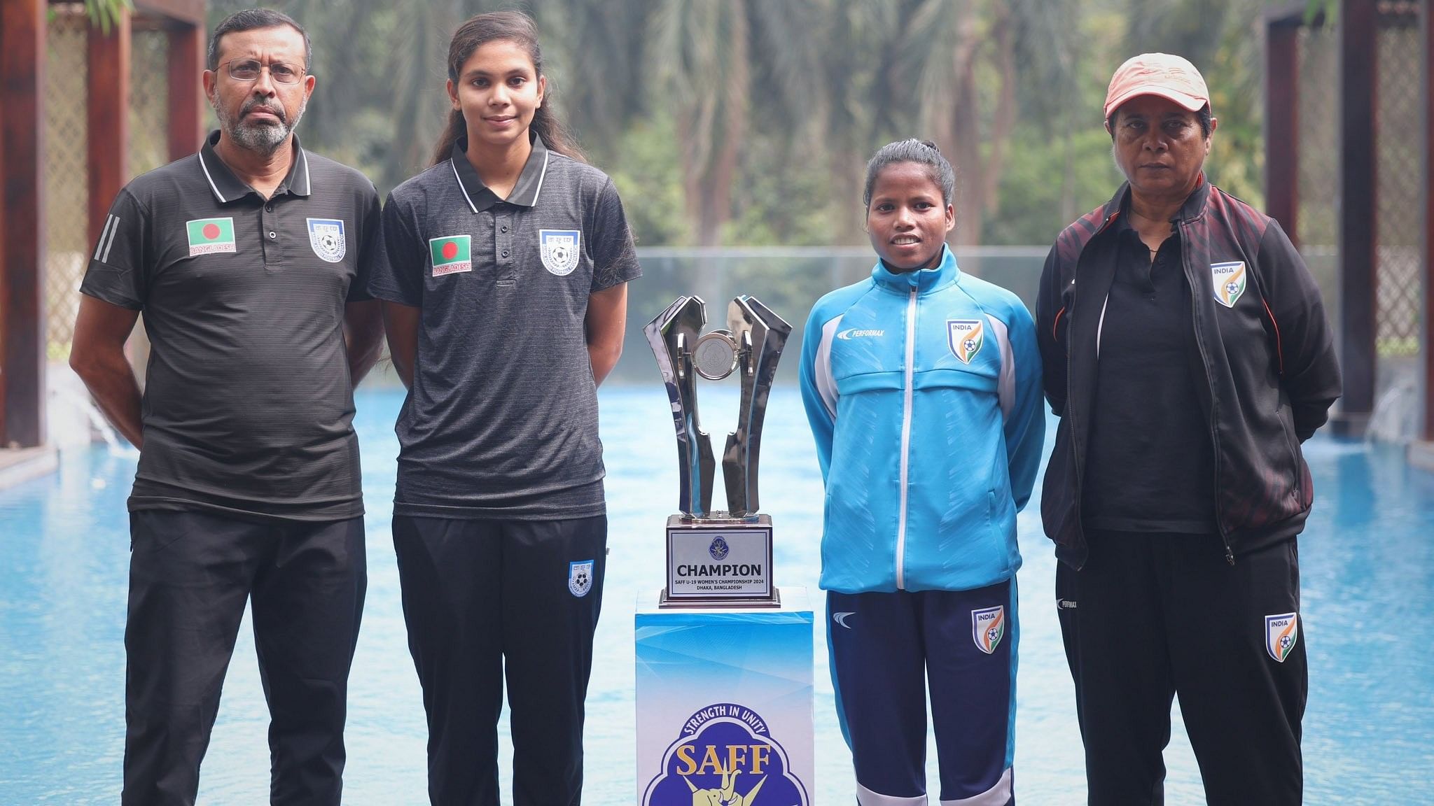 <div class="paragraphs"><p>India’s newly appointed U-19 women’s captain Nitu Linda with coach&nbsp;Sukla Dutta, along with their&nbsp;Bangladesh counterpart, pose with SAFF U-19 Women's Championship trophy  ahead of the final in Dhaka</p></div>