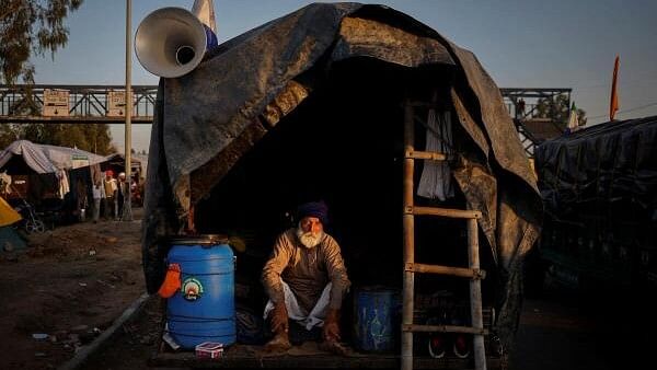 <div class="paragraphs"><p>A farmer sits inside a tractor trolley as farmers march towards New Delhi to push for better crop prices promised to them in 2021, at Shambhu Border.</p></div>