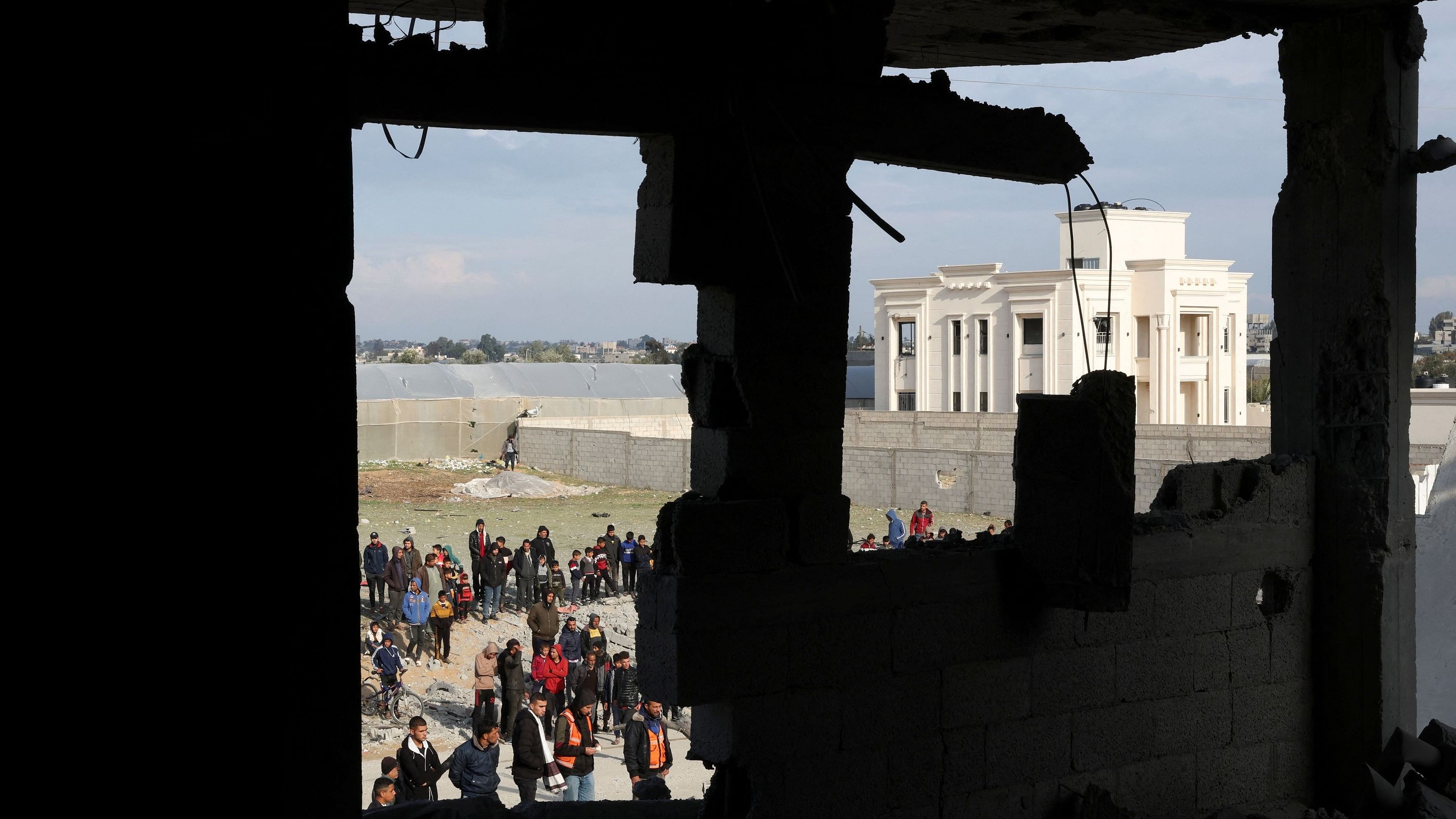 <div class="paragraphs"><p>Palestinians gather near a house hit by an Israeli strike, in Rafah in the southern Gaza Strip February 16, 2024. </p></div>