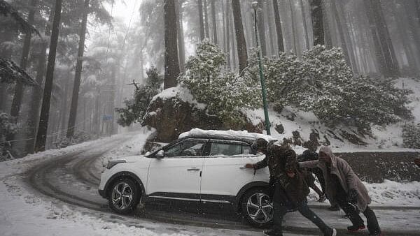 <div class="paragraphs"><p>People push a car on a snow-covered road after a fresh snowfall, in Jammu, Sunday, Feb. 4, 2024.</p></div>