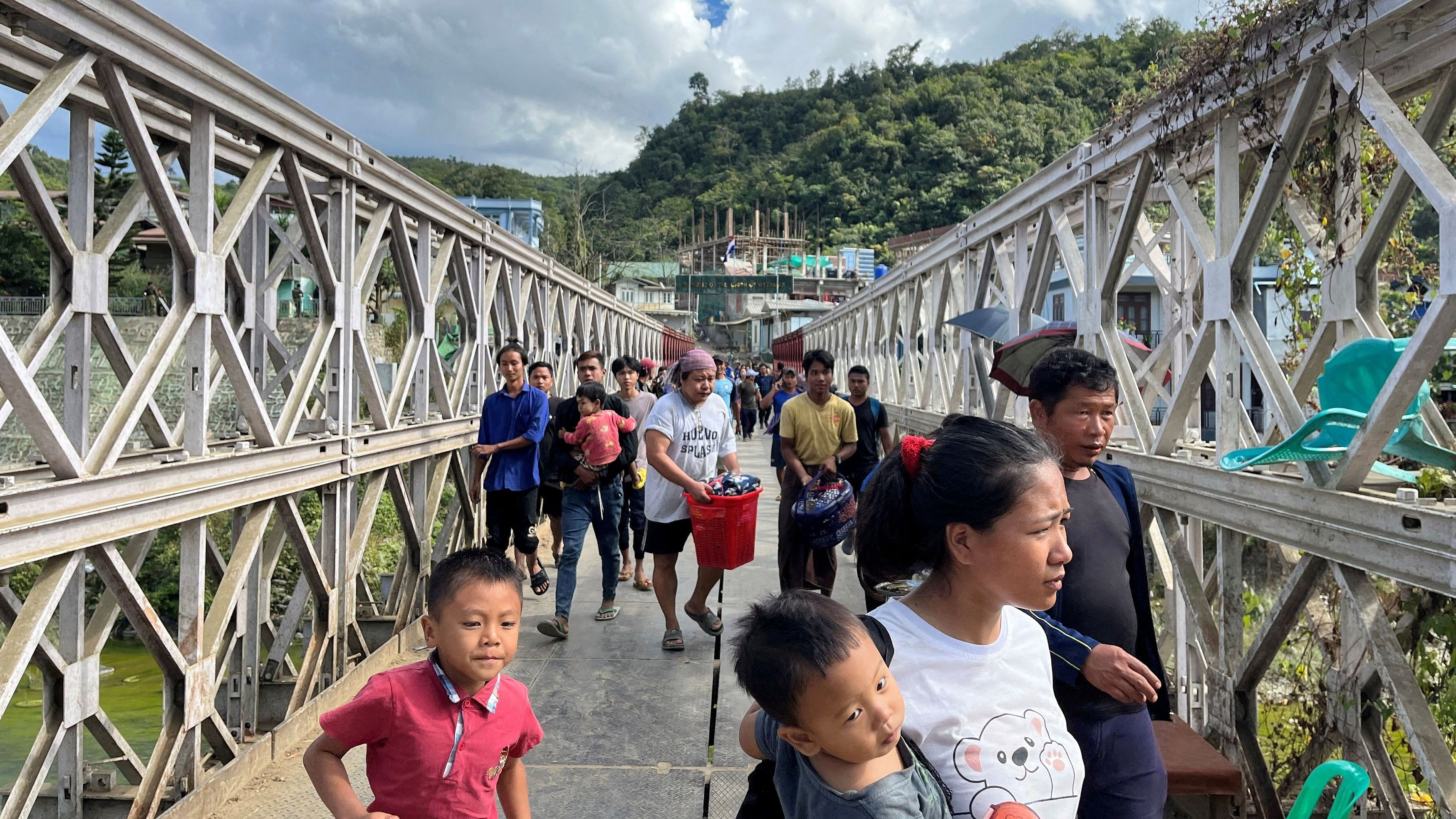 <div class="paragraphs"><p>People who fled Myanmar carry their belongings across a bridge that connects Myanmar and India at the border village of Zokhawthar, Champhai district, in Mizoram, November 15, 2023.</p></div>