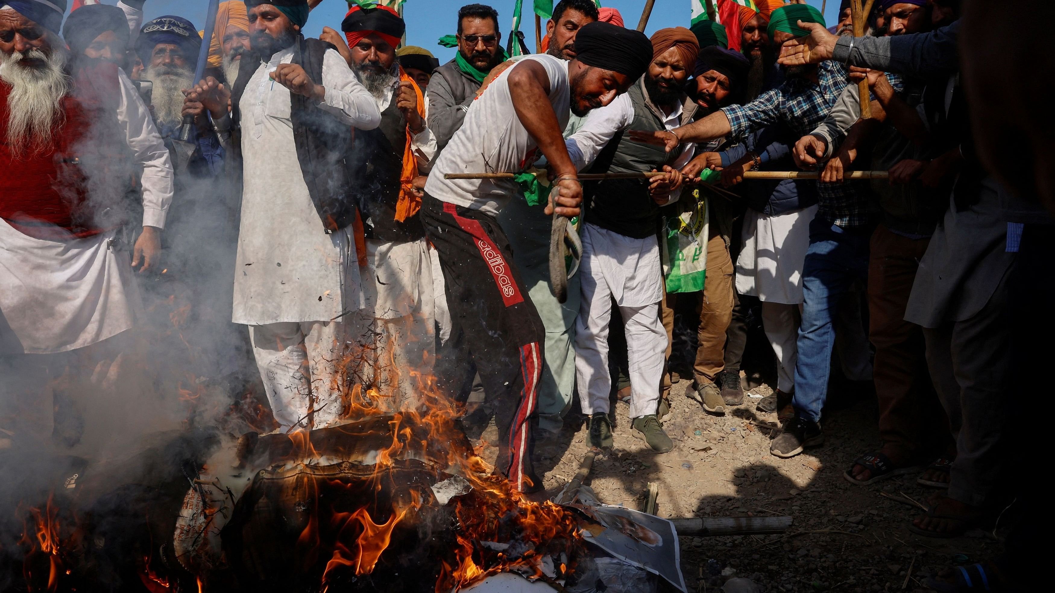 <div class="paragraphs"><p>Farmers shout slogans as they burn an effigy of Prime Minister Narendra Modi and other ministers at a protest site.</p></div>