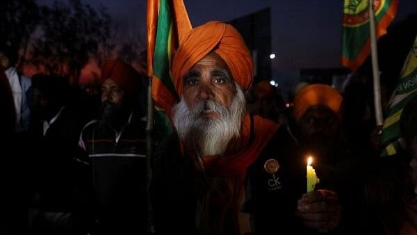 <div class="paragraphs"><p>A farmer reacts during a candle light protest after a death of a protestor, during the march towards New Delhi to push for better crop prices promised to them in 2021, at Shambhu Barrier, the border between Punjab and Haryana states, India February 23, 2024.</p></div>
