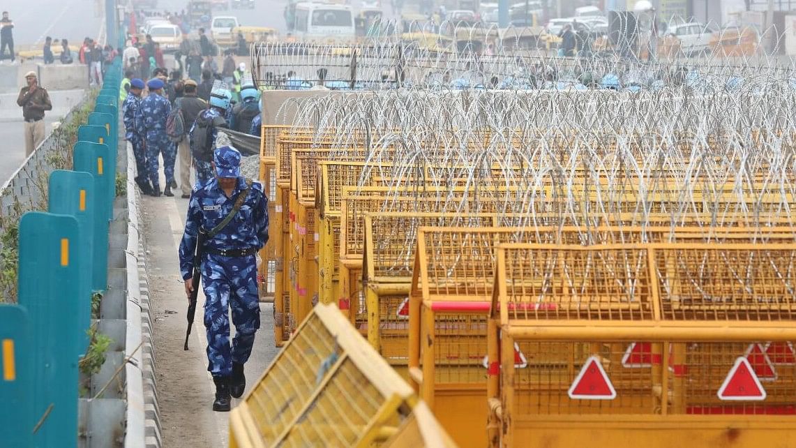 <div class="paragraphs"><p>Police and security personnel keep a vigil near multi-layered barricading ahead of the protesting farmers’ ‘Delhi Chalo’ March, at the Singhu Border, in New Delhi</p></div>