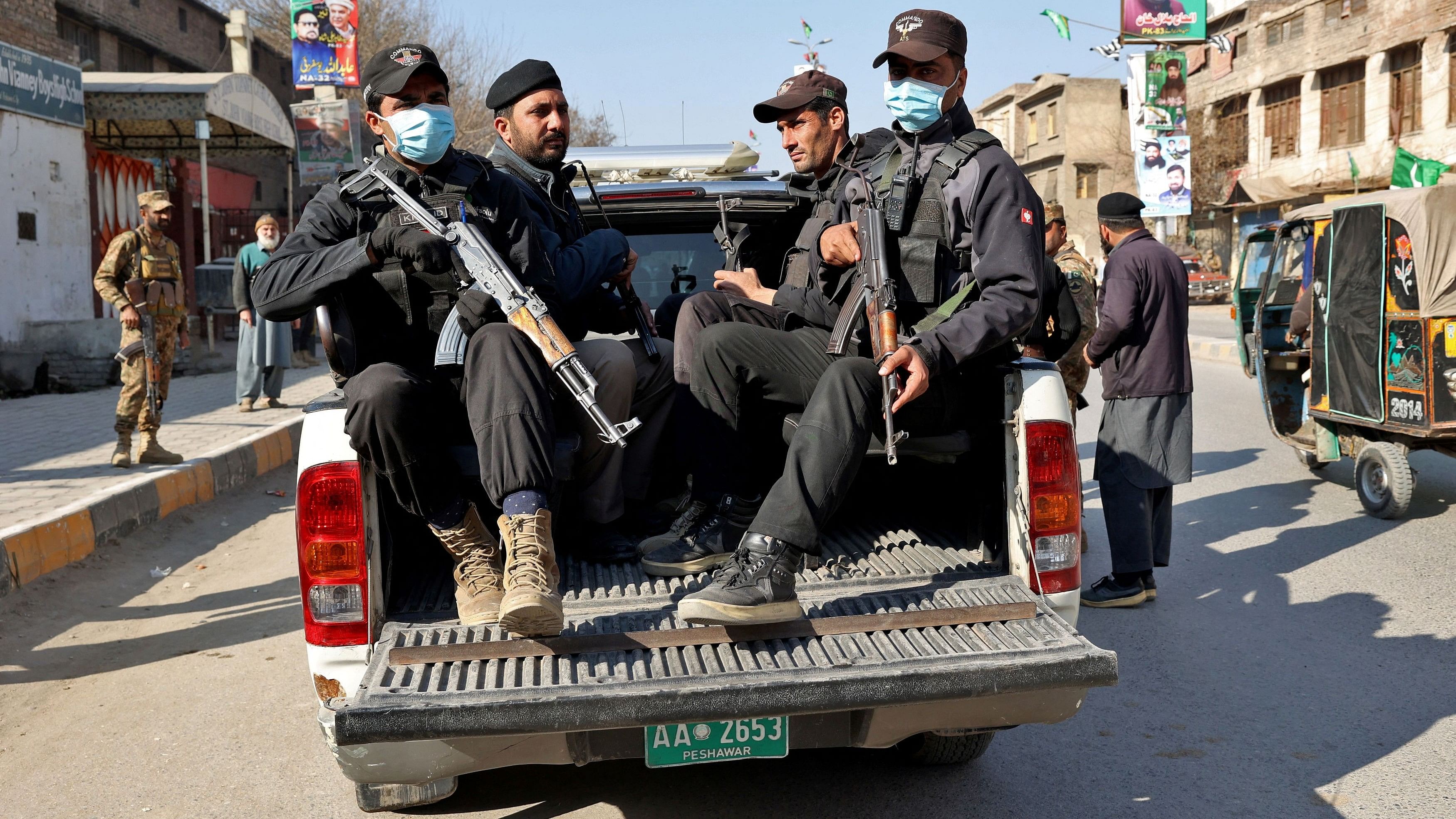 <div class="paragraphs"><p>Police officers stand guard in a vehicle outside a polling station during general election, in Peshawar, Pakistan, February 8, 2024.</p></div>