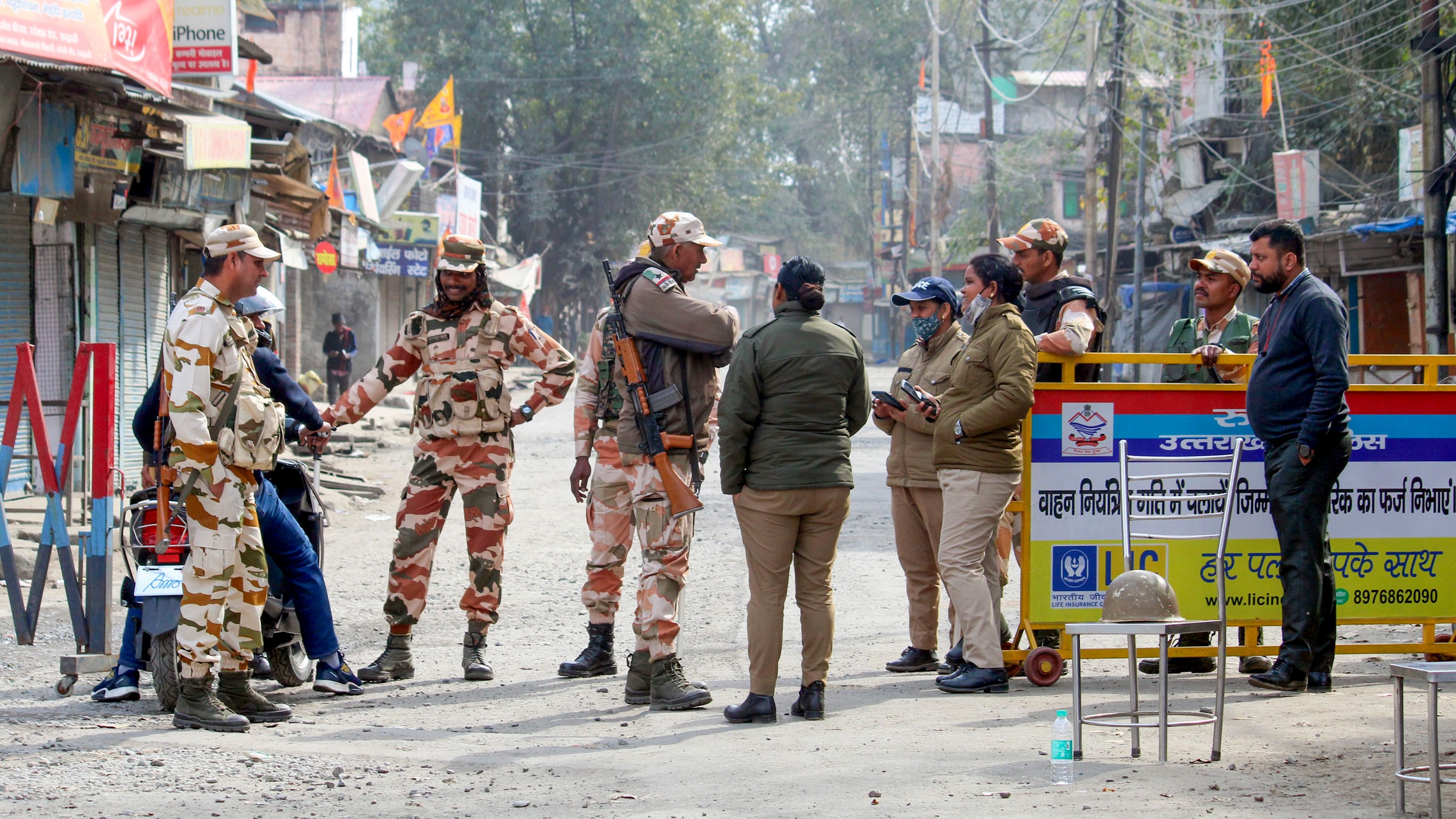 <div class="paragraphs"><p>Security personnel guard a road during a curfew at Banbhoolpura area, following incidents of violence in Haldwani, Feb 12, 2024.</p></div>