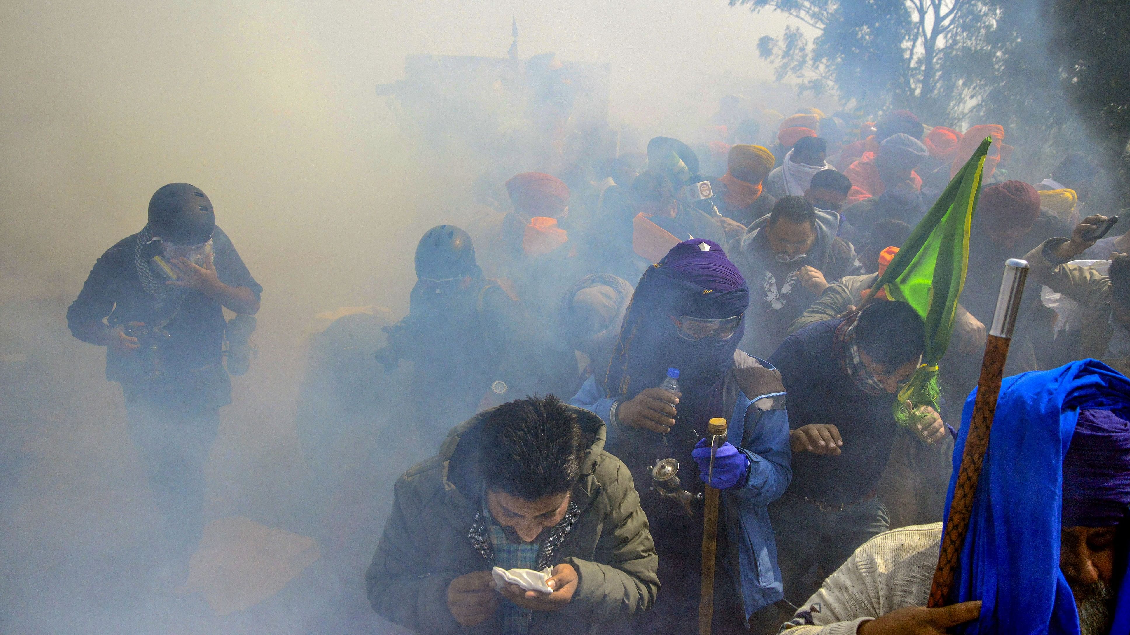 <div class="paragraphs"><p>Farmers look for cover after police fired tear gas at them during their 'Dilli Chalo' march, near the Punjab-Haryana Shambhu border, in Patiala district, on Wednesday</p></div>