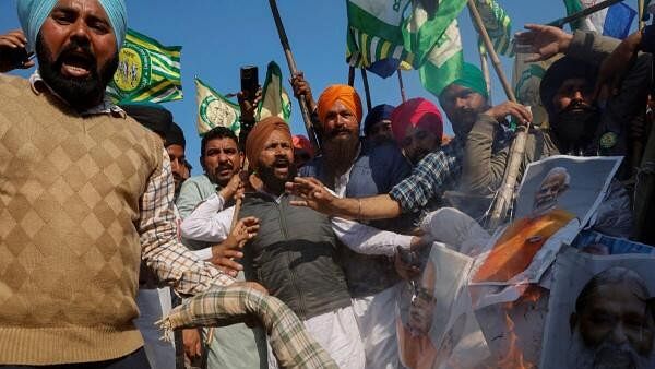 <div class="paragraphs"><p>Farmers shout slogans as they burn an effigy of Prime Minister Narendra Modi and other ministers at a protest site, during the march towards New Delhi to push for better crop prices promised to them in 2021, at Shambhu Barrier, the border between Punjab and Haryana states, India February 23, 2024.</p></div>