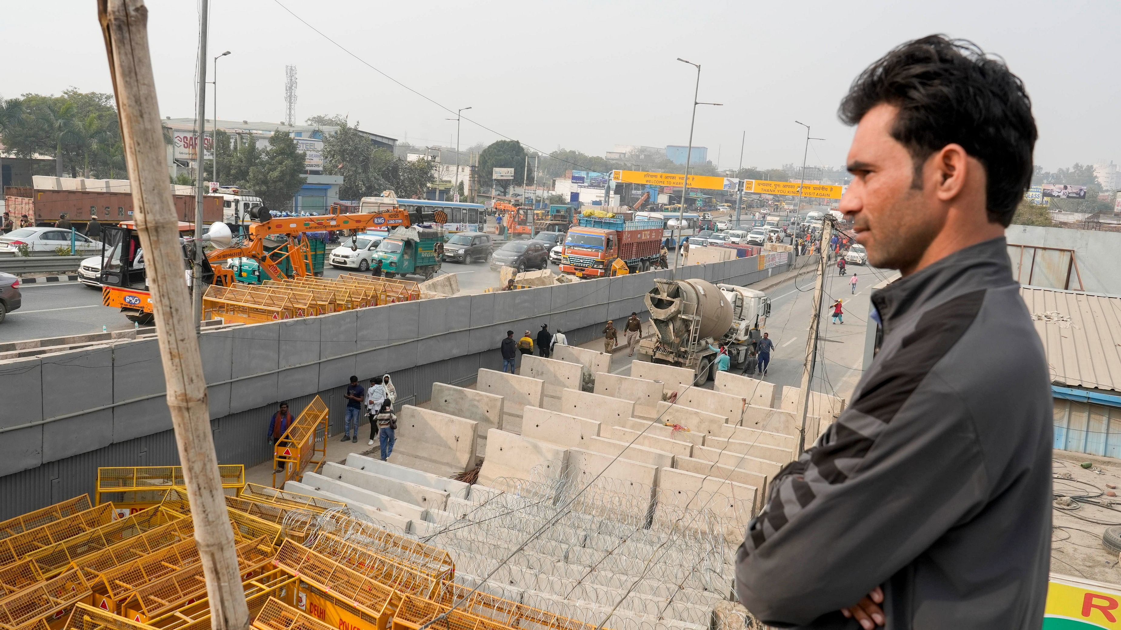 <div class="paragraphs"><p>A local resident looks at the multi-layered barricading placed at Singhu Border ahead of the scheduled march by the protesting farmers, in New Delhi.</p></div>