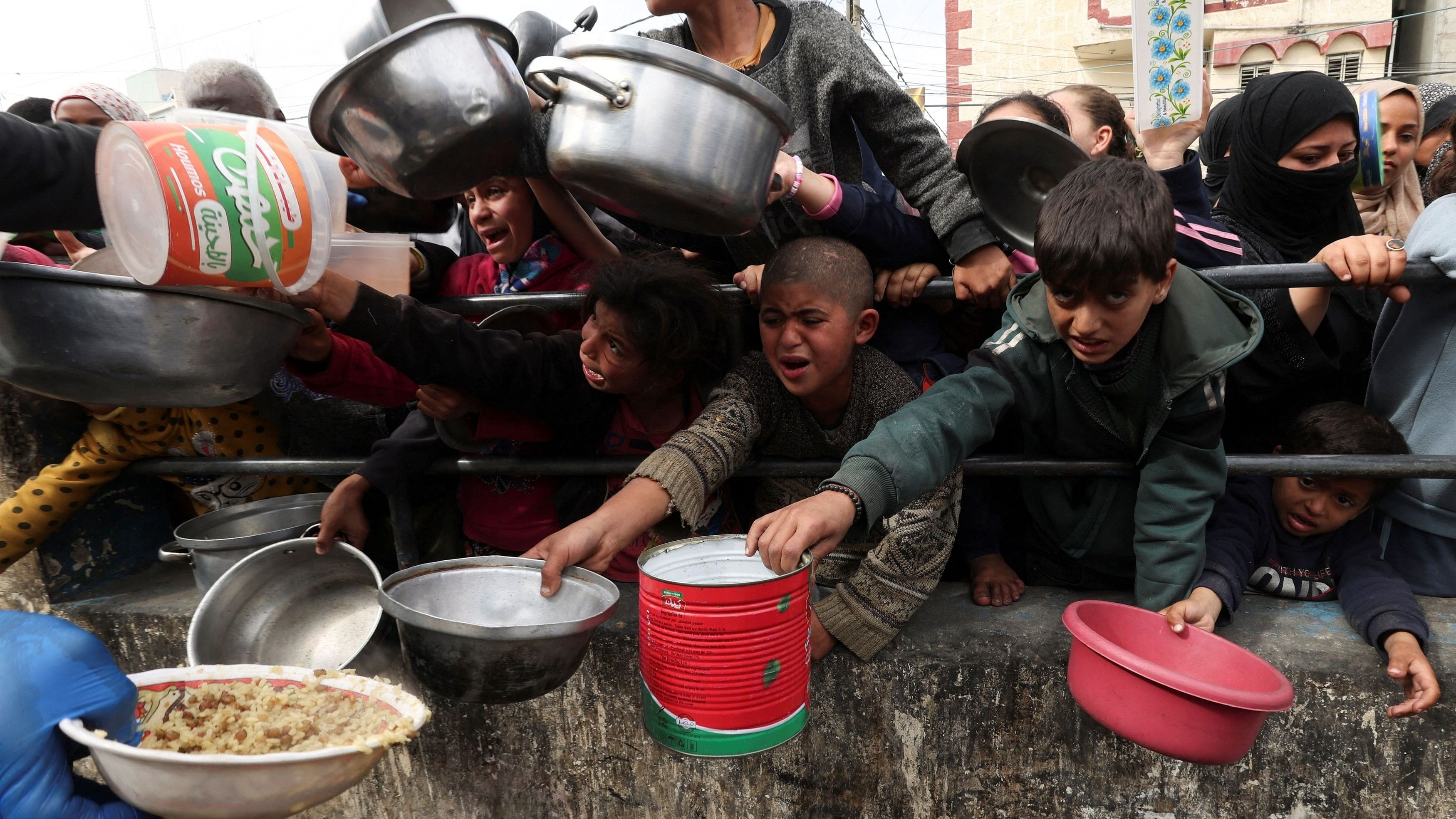 <div class="paragraphs"><p>Palestinian children wait to receive food cooked by a charity kitchen amid shortages of food supplies, as the ongoing conflict between Israel and the Palestinian Islamist group Hamas continues, in Rafah, in the southern Gaza Strip, February 13, 2024. </p></div>