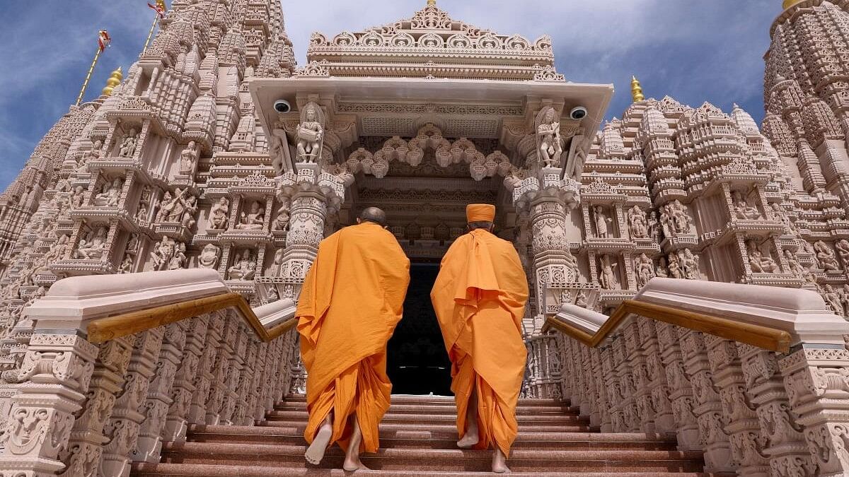 <div class="paragraphs"><p>Monks walk at the BAPS Hindu Mandir temple, in Abu Dhabi, United Arab Emirates.</p></div>