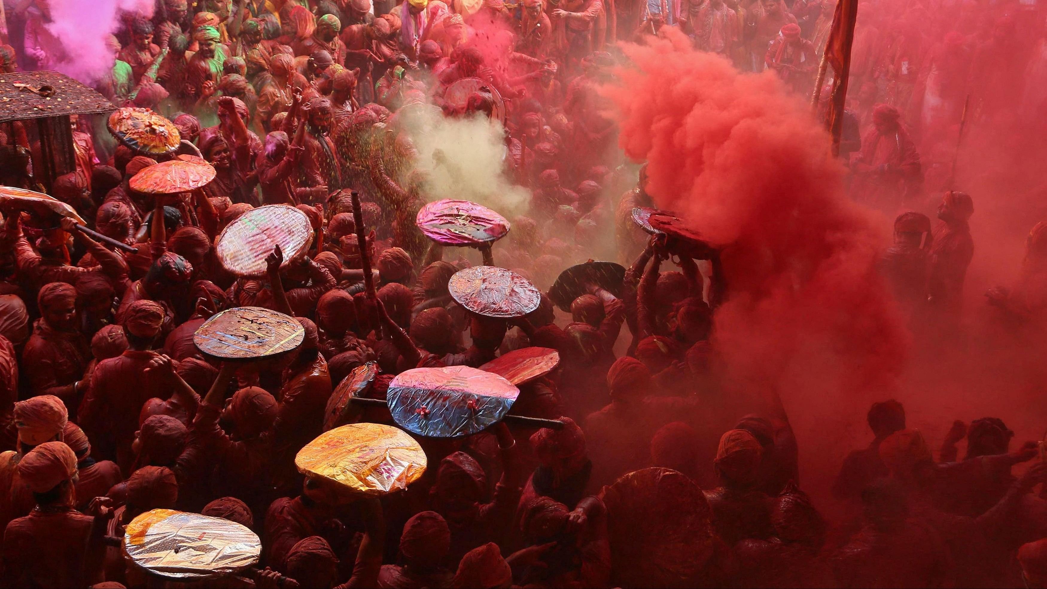 <div class="paragraphs"><p>Men daubed in colours throw coloured powder at each other during "Lathmar Holi" celebrations inside a temple in the town of Barsana, Uttar Pradesh, India, March 18, 2024. </p></div>