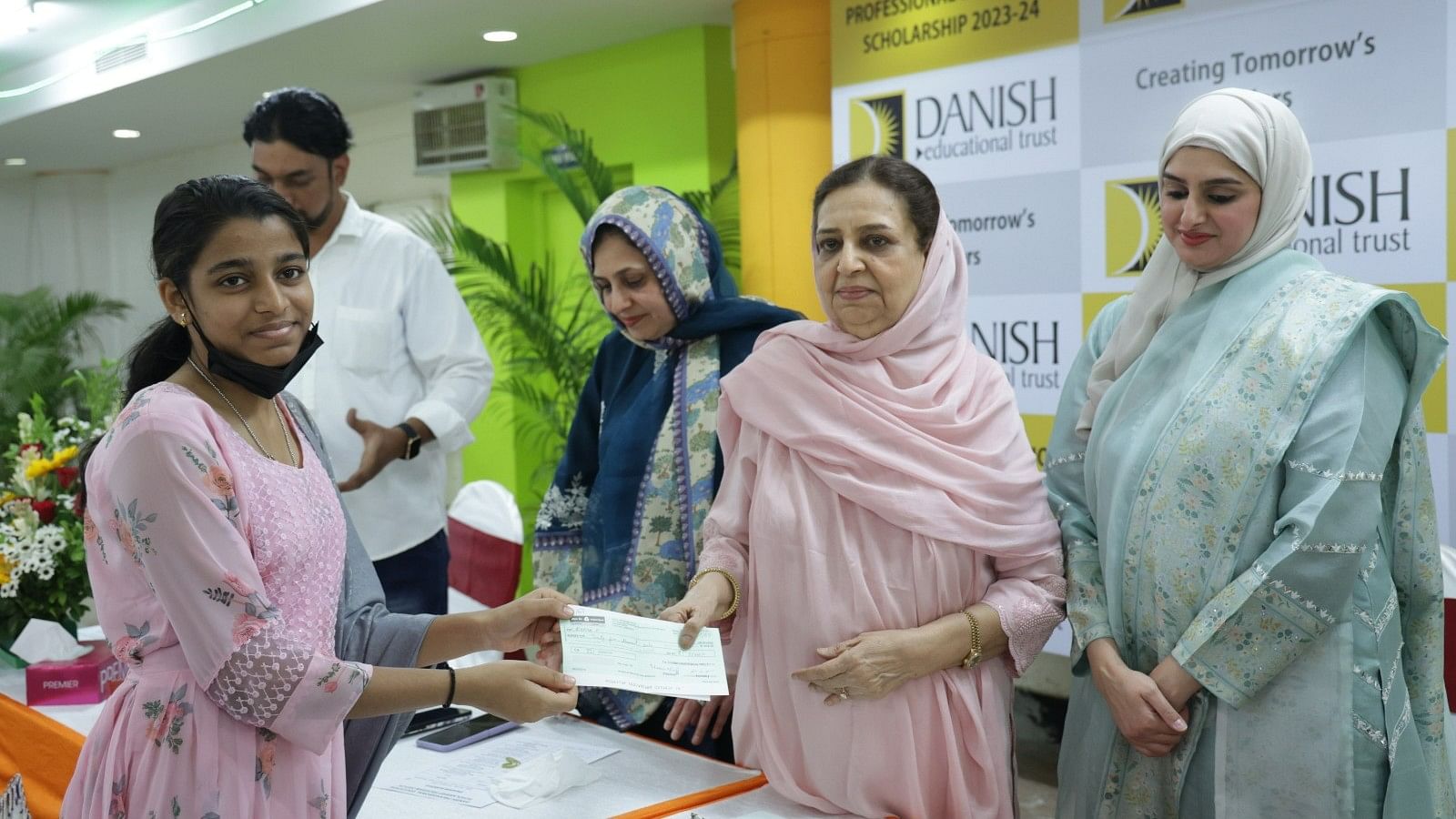 <div class="paragraphs"><p>A student receives a scholarship cheque from Danish Educational Trust's Husna Sheriff on Sunday. </p></div>