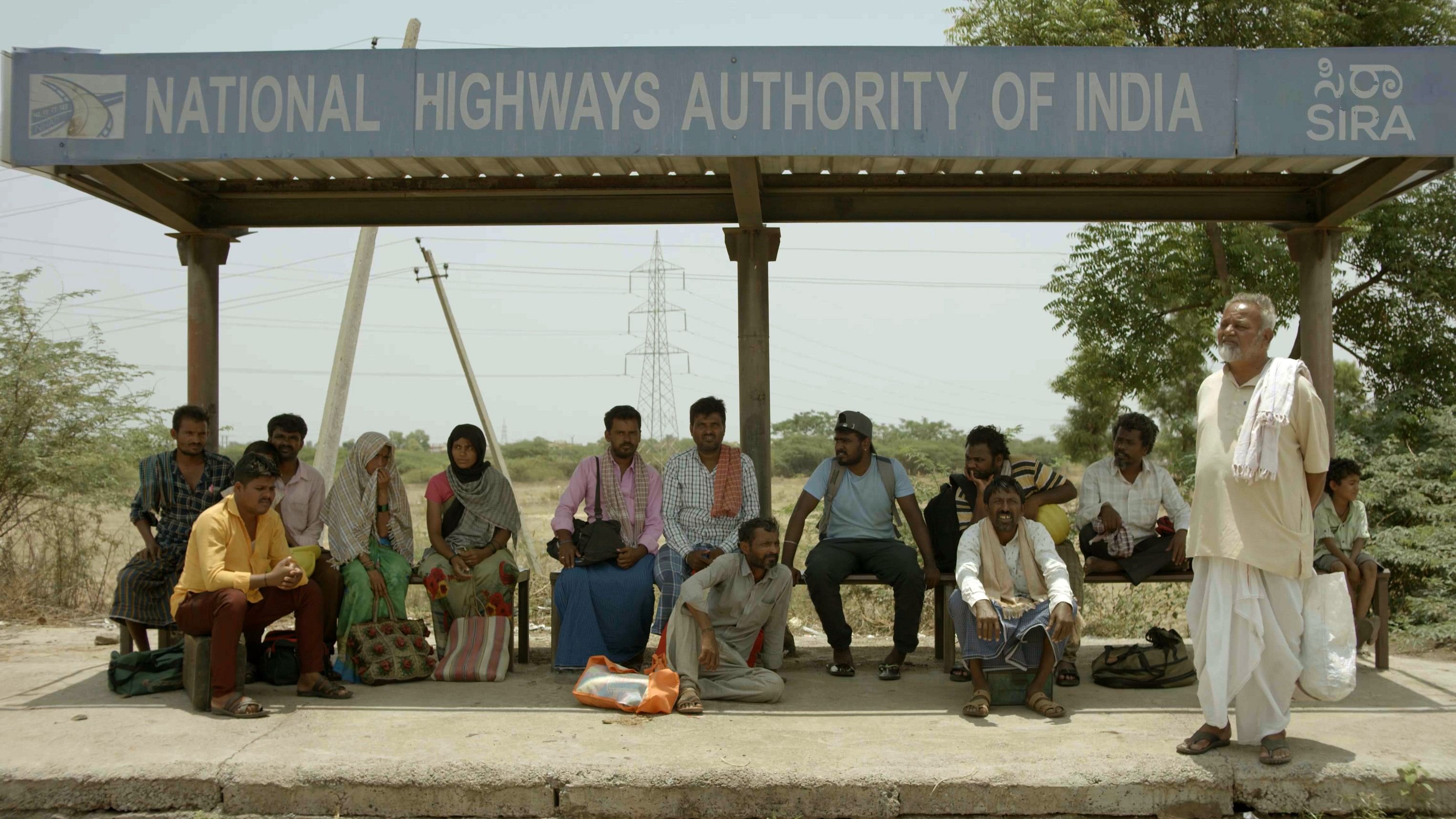 <div class="paragraphs"><p>Migrant workers wait for a bus in a still from the film. </p></div>