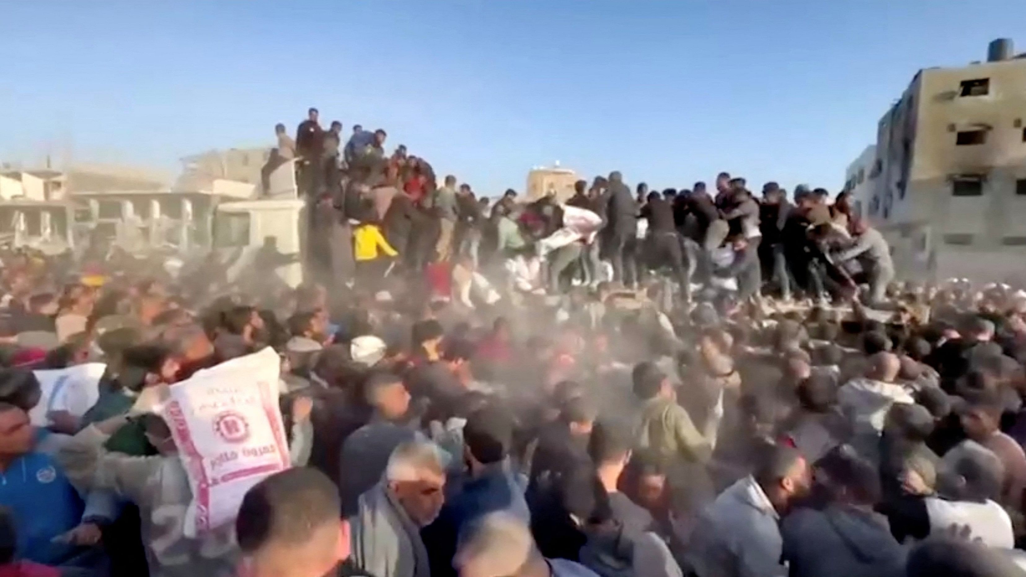 <div class="paragraphs"><p>People rush towards an aid truck carrying bags of flour in Al Zaytun neighbourhood, amid the ongoing conflict between Israel and the Palestinian Islamist group Hamas, in Gaza City, in this still picture taken from a video, March 2, 2024.  </p></div>