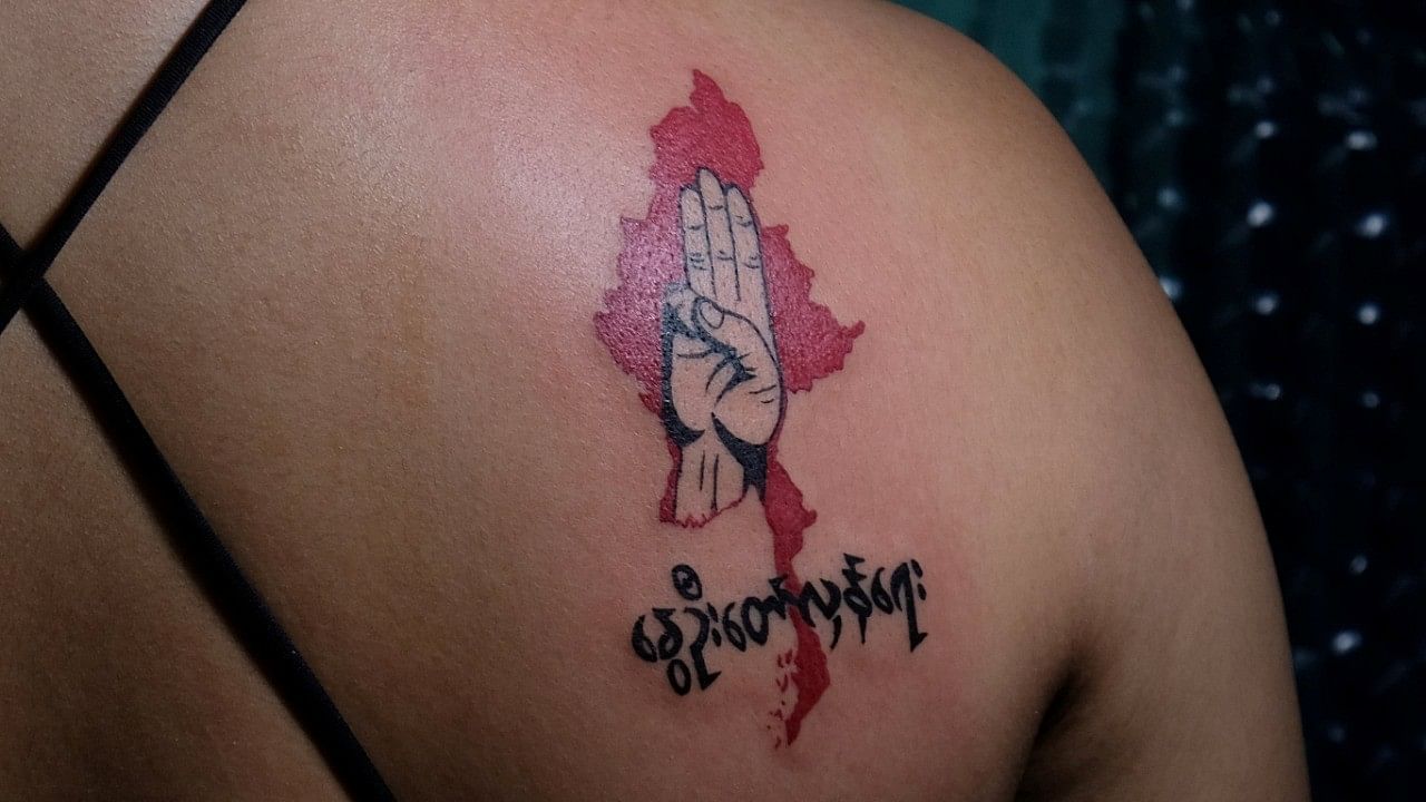 <div class="paragraphs"><p>A woman displays a tattoo with a three-finger salute and the phrase 'spring revolution' over a map of Myanmar after it was finished in a tattoo shop in Yangon. </p></div>