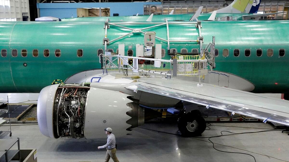 <div class="paragraphs"><p>A worker walks past Boeing's new 737 MAX-9 under construction at their production facility in Renton.</p></div>