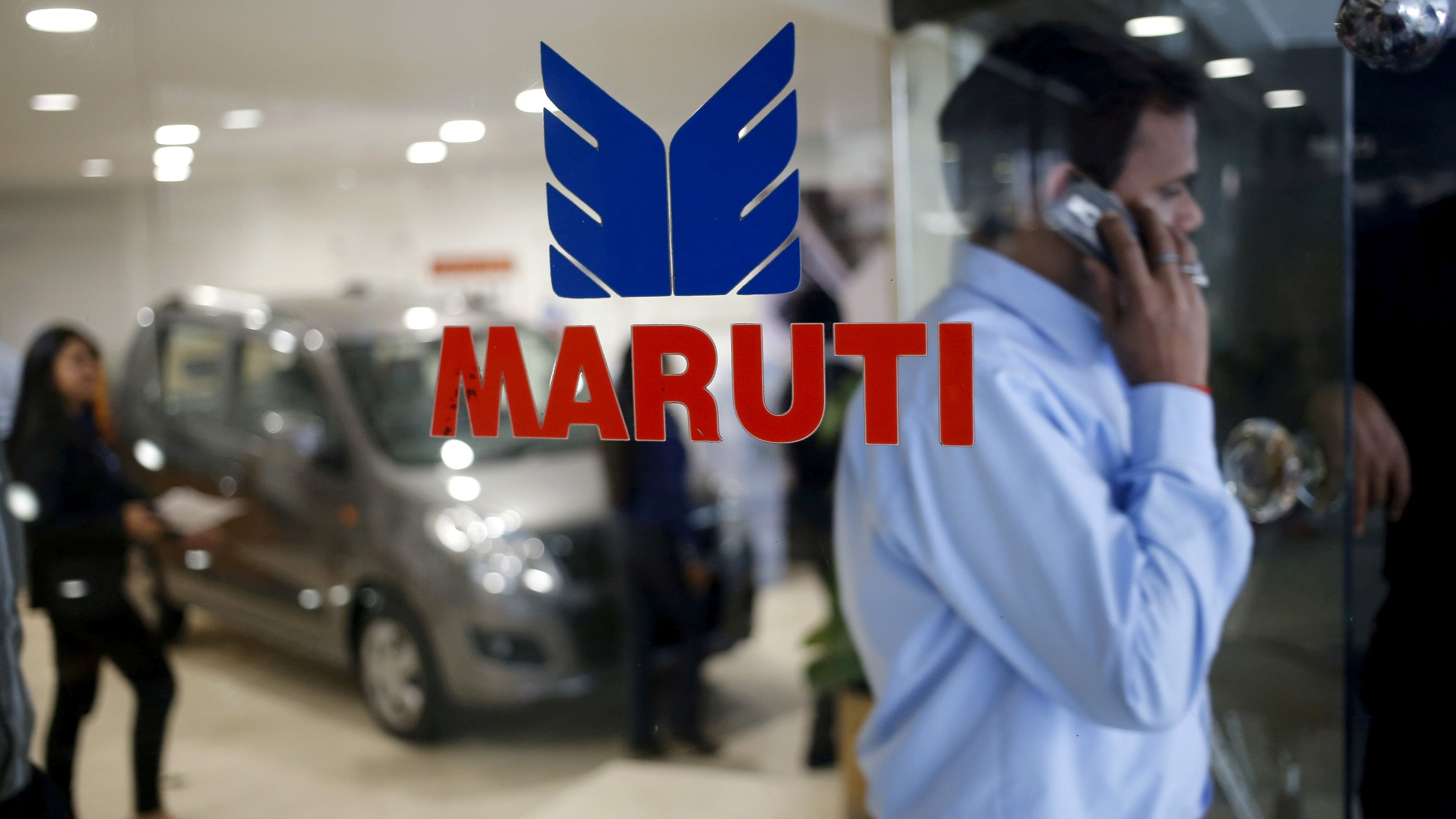 <div class="paragraphs"><p>A man speaks on his mobile phone as he exits a glass door with the logo of Maruti Suzuki India Limited at a showroom in New Delhi.</p></div>