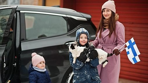 <div class="paragraphs"><p>Kids with cat on hands against car in the yard of house at winter. Mother hold flag of Finland.</p></div>