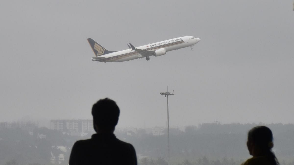 <div class="paragraphs"><p>People watch an aircraft flaying during in drizzling at the Kempegowda International Airport in Bengaluru</p></div>