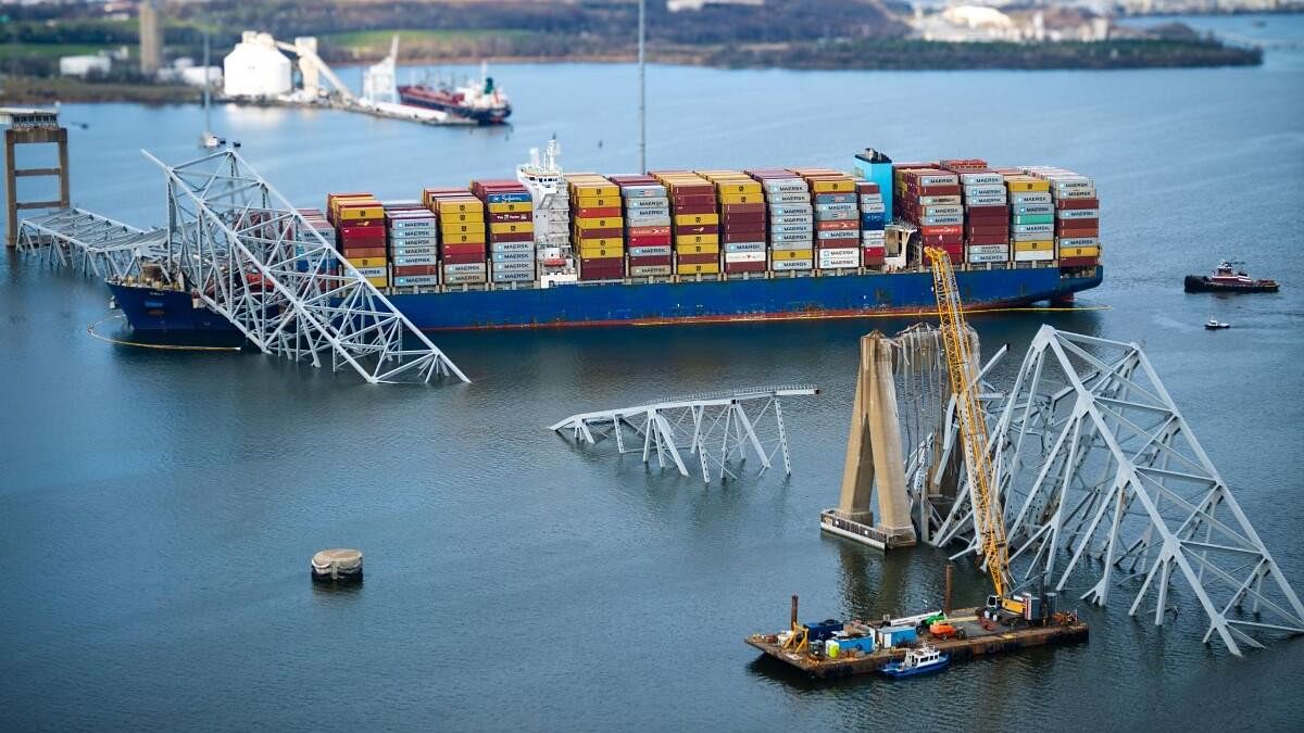 <div class="paragraphs"><p>The Singapore-flagged cargo ship Dali is seen stuck during an overflight assessment of the Francis Scott Key Bridge collapse, as a crane ship is anchored nearby in Baltimore.</p></div>