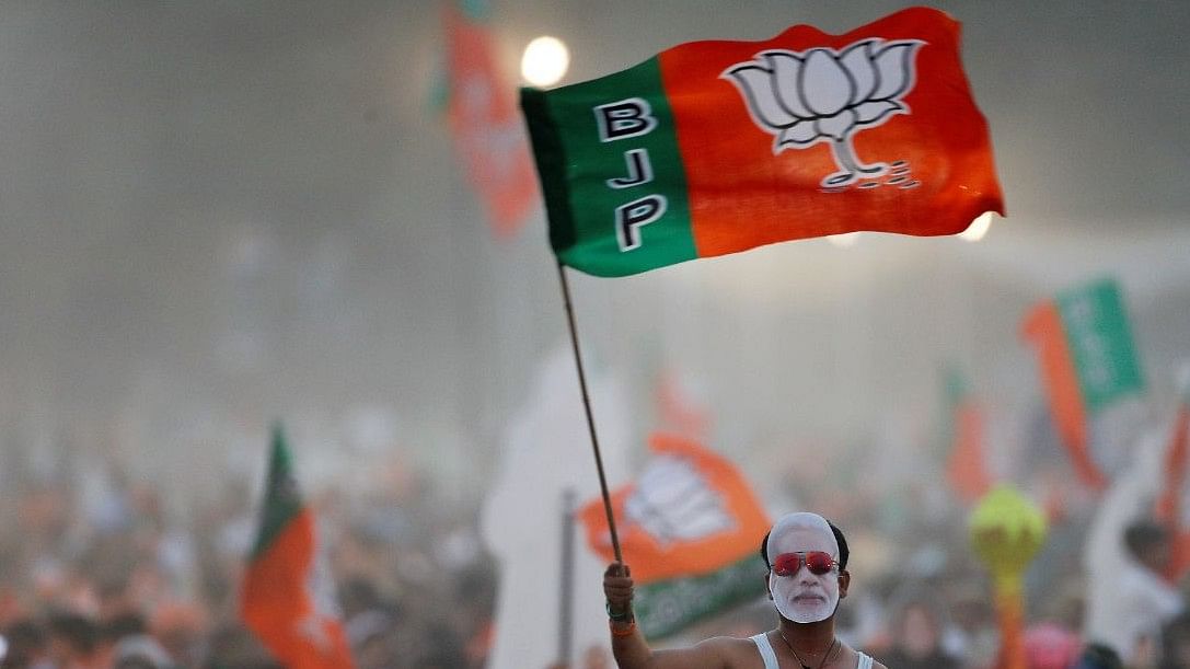 <div class="paragraphs"><p>The Bharatiya Janata Party (BJP) supporter waves a party flag wearing a Modi mask. Representative image. </p></div>