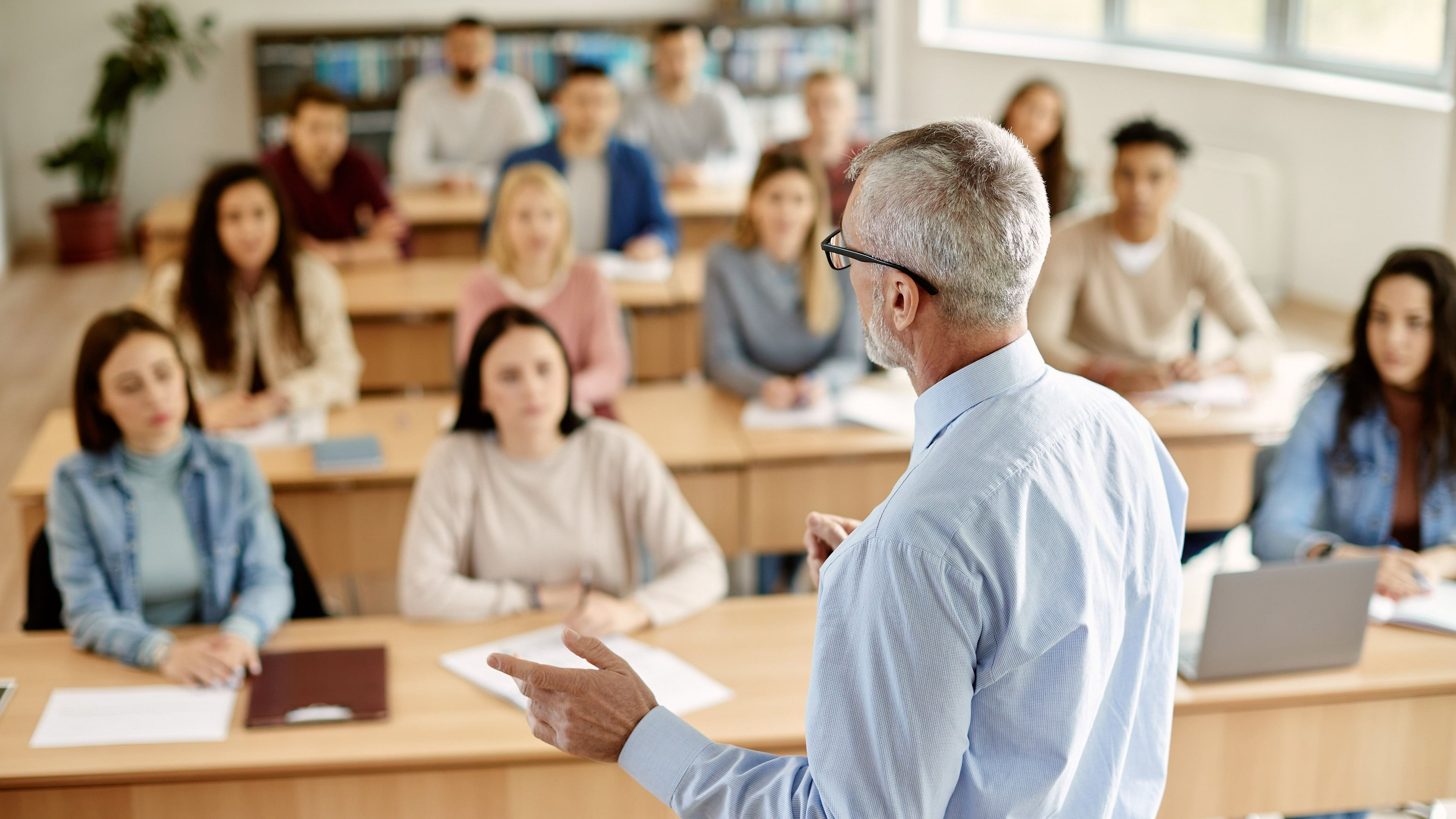 <div class="paragraphs"><p>A professor addressing college students in a classroom. </p></div>