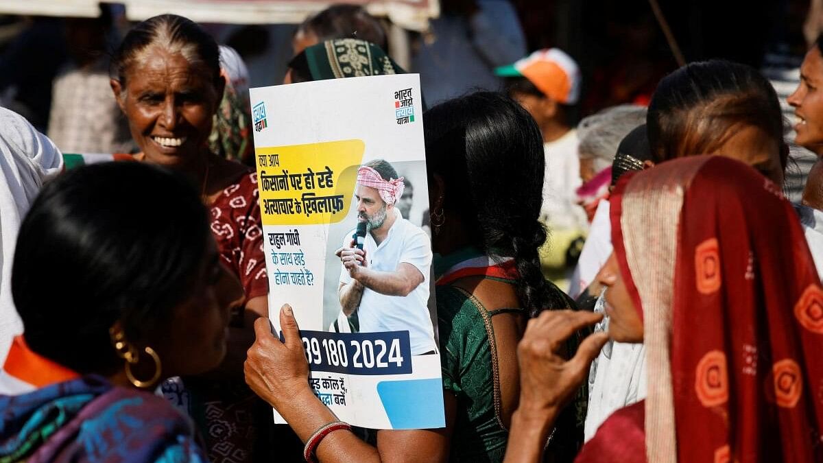 <div class="paragraphs"><p>A supporter of Rahul Gandhi, a senior leader of India's main opposition Congress party, holds a party placard to protect from heat, at a roadshow during Rahul's 66-day long 'Bharat Jodo Nyay Yatra', or Unite India Justice March, in Halol town, Gujarat state, India, March 8, 2024.</p></div>