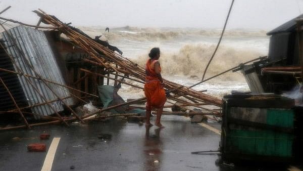 <div class="paragraphs"><p>A woman stands next to her stall damaged by heavy winds at a shore ahead of Cyclone Yaas in Odisha,&nbsp;May 26, 2021.</p></div>