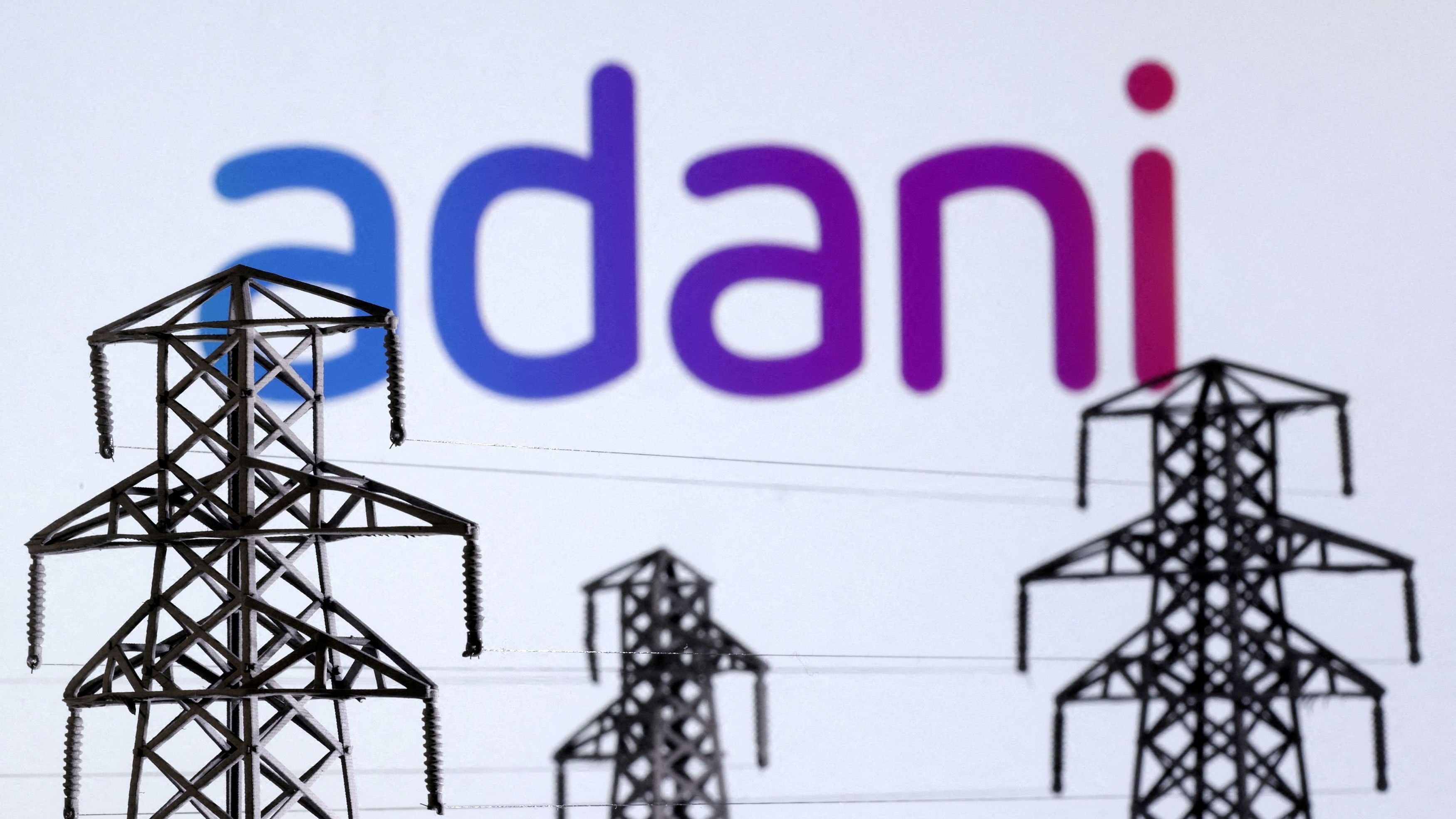 <div class="paragraphs"><p>FILE PHOTO: Electric power transmission pylon miniatures and Adani Green Energy logo are seen in this illustration taken, December 9, 2022. </p></div>