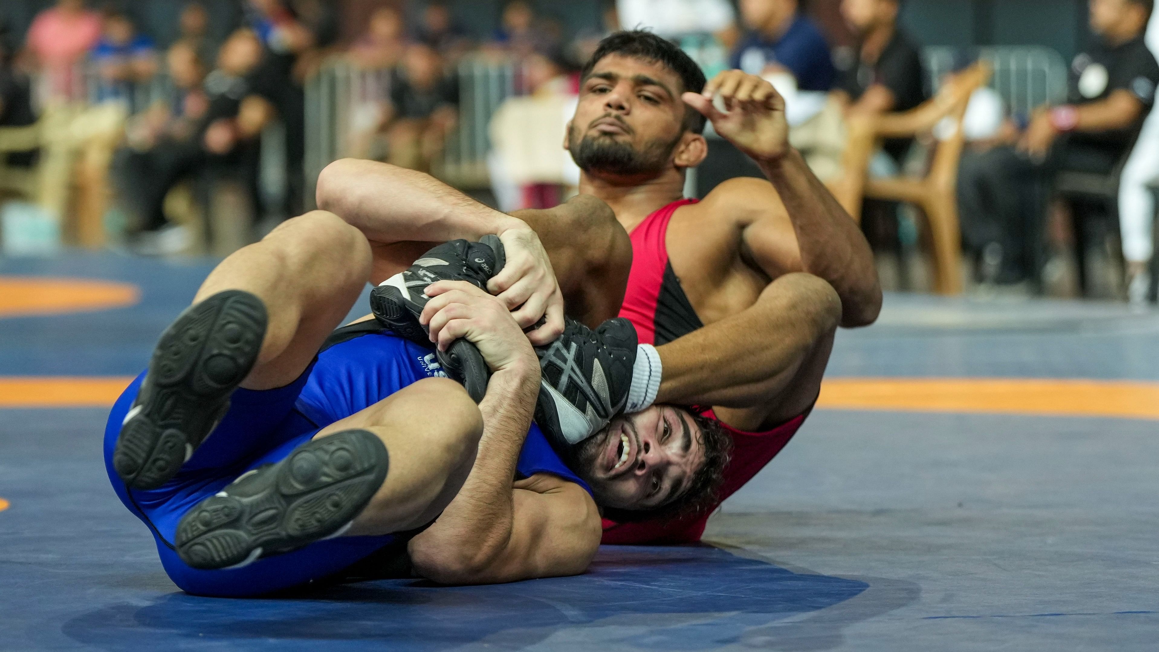 <div class="paragraphs"><p>A file photo of&nbsp;Atish Todkar of Maharashtra (in red) and Rahul of Delhi compete in the men's freestyle 57 kg category event during the Asian Games 2023 wrestling trials, at IG Stadium in New Delhi.</p></div>