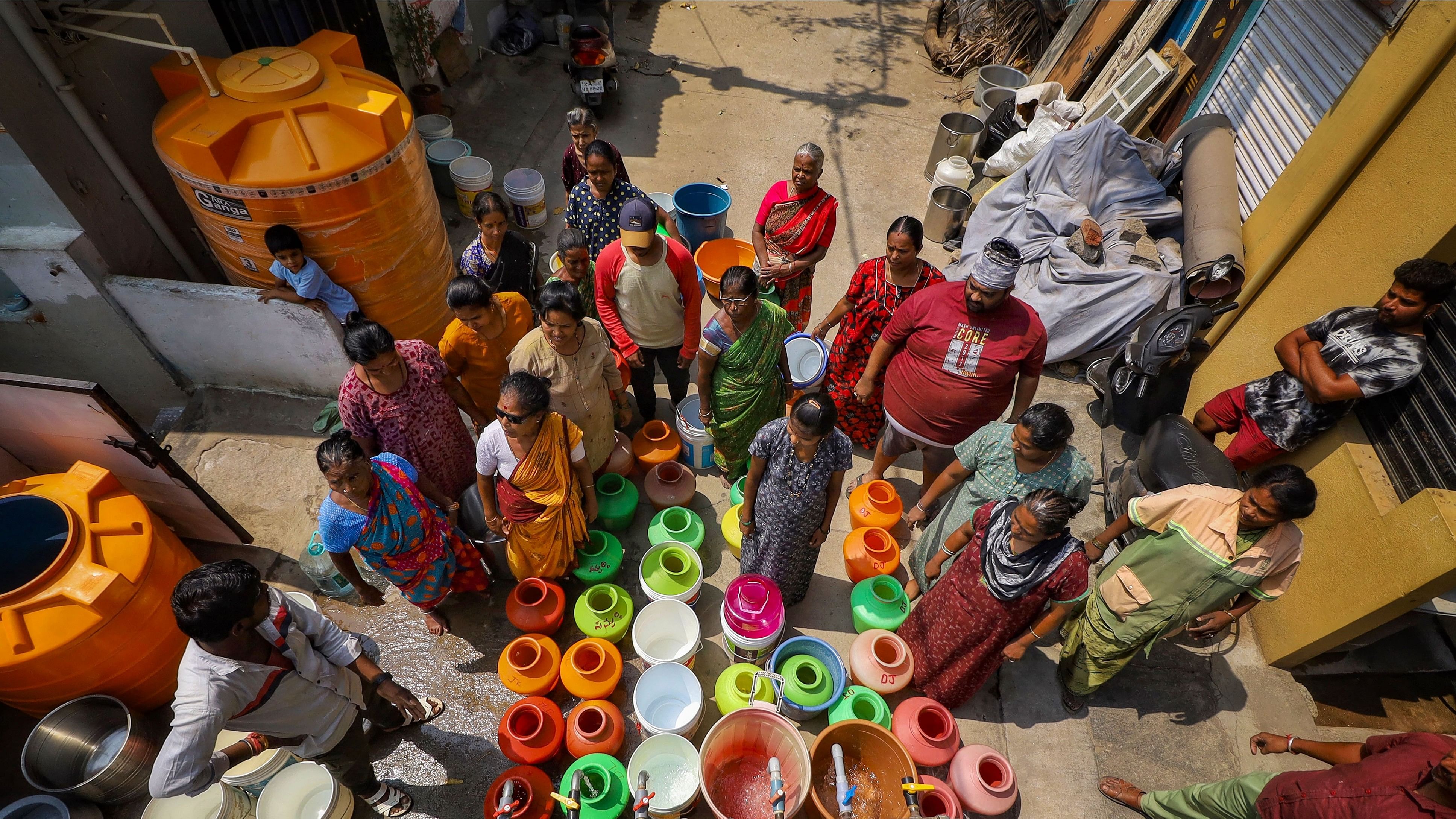 <div class="paragraphs"><p>People collect free drinking water from a tanker due to the ongoing water crisis, in Bengaluru, Wednesday. </p></div>