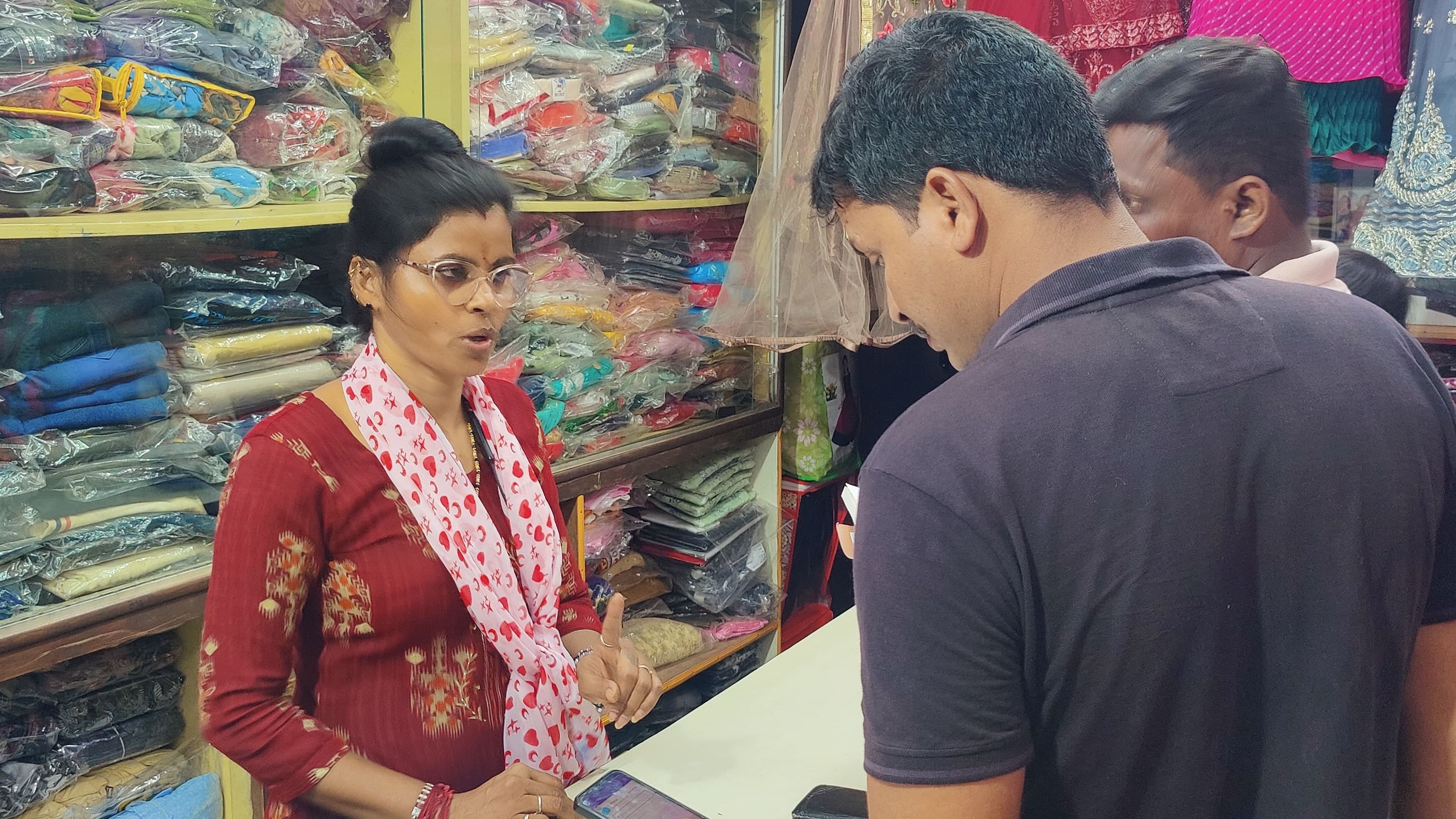 <div class="paragraphs"><p>Sujatha speaks to customers at her tailoring shop.</p></div>