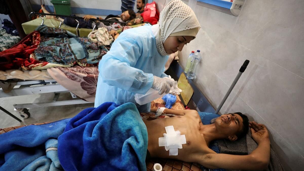 <div class="paragraphs"><p>A Palestinian man who was wounded in Israeli fire while waiting for aid, according to health officials, lies on a bed at Al Shifa hospital, amid the ongoing conflict between Israel and Hamas, in Gaza City, March 1, 2024.</p></div>