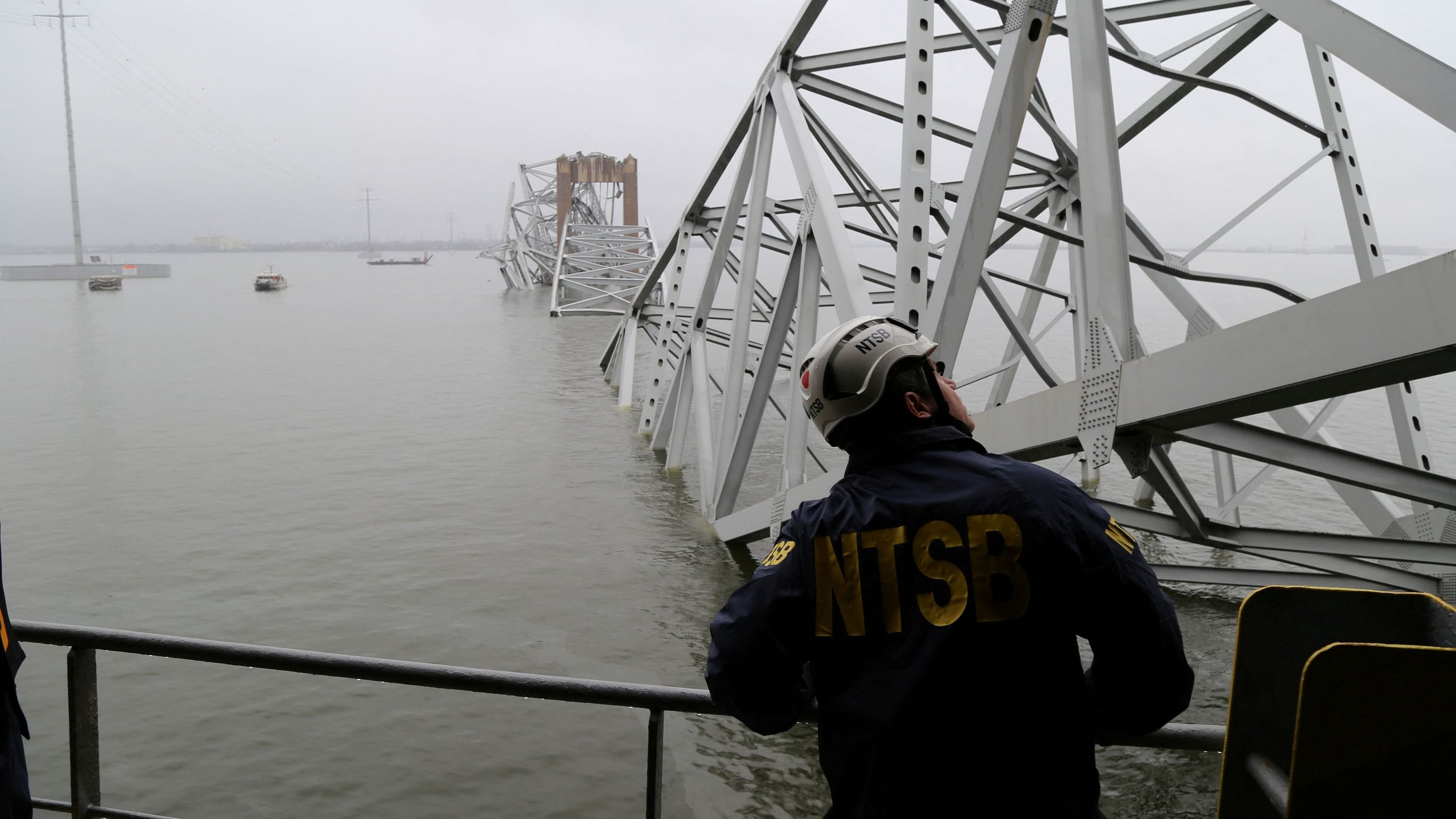 <div class="paragraphs"><p>A National Transportation Safety Board (NTSB) worker looks on at the cargo vessel Dali, which struck and collapsed the Francis Scott Key Bridge, in Baltimore, Maryland </p></div>