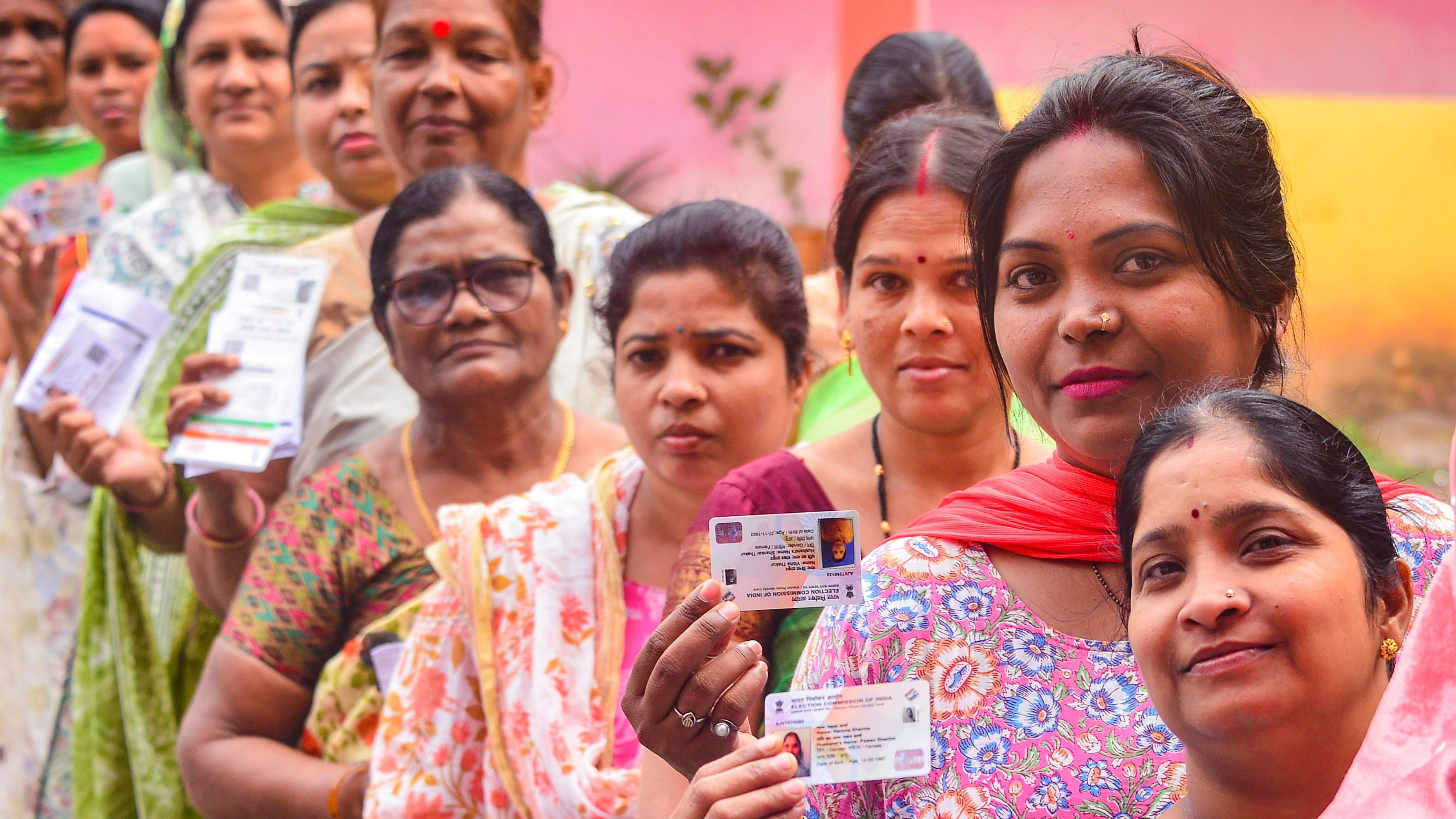 <div class="paragraphs"><p>  Voters show their identification cards as they wait in a queue to cast their votes at a polling station. Representative photo.</p></div>