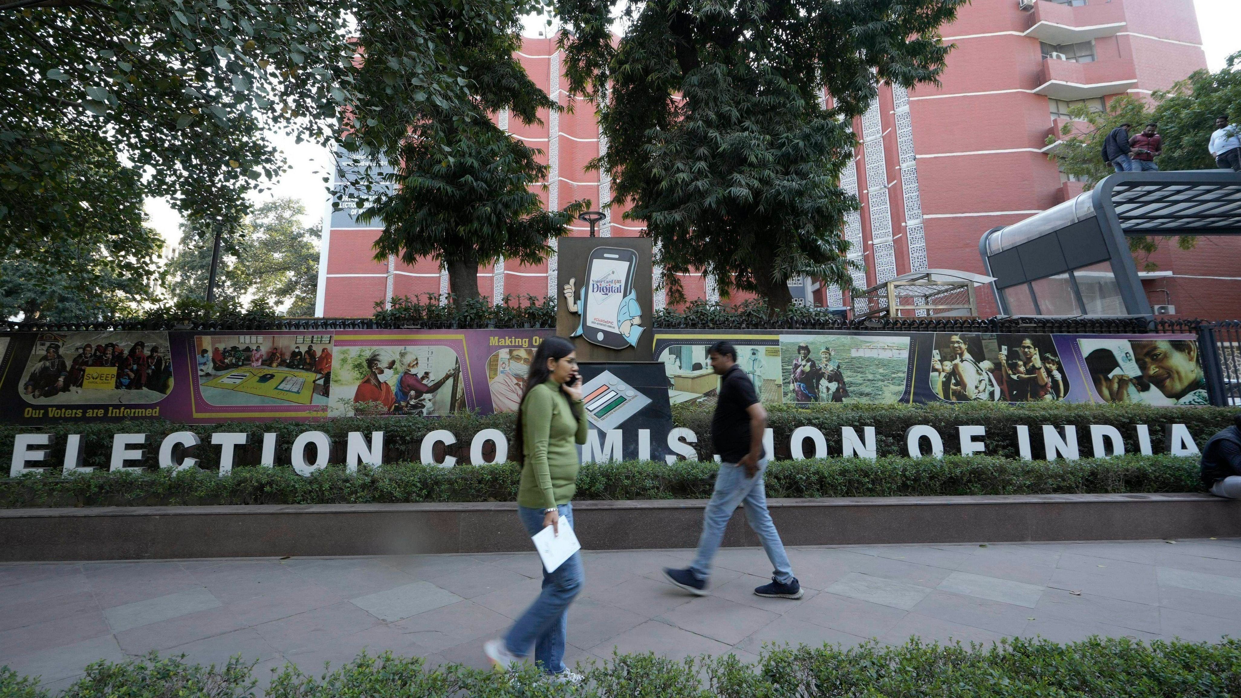 <div class="paragraphs"><p>People walk past the Election Commission of India premises, in New Delhi.</p></div>