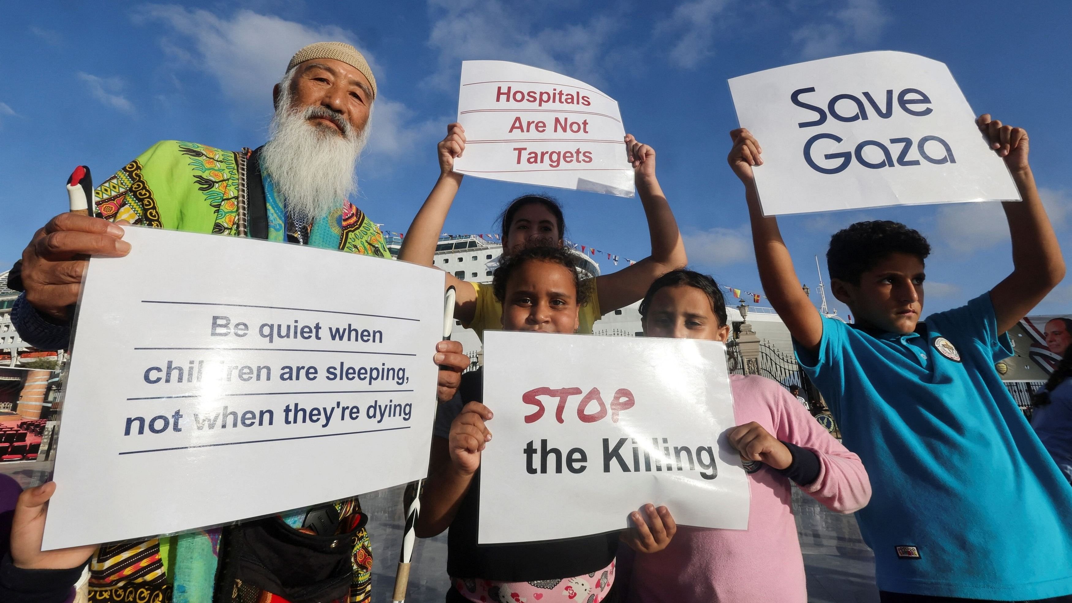 <div class="paragraphs"><p>An activist and Egyptian children carry placards in support of Gaza, in front of the Japan-based NGO Peace Boat's cruise ship Pacific World, which displays a banner reading "Stop Killing Gaza".</p></div>