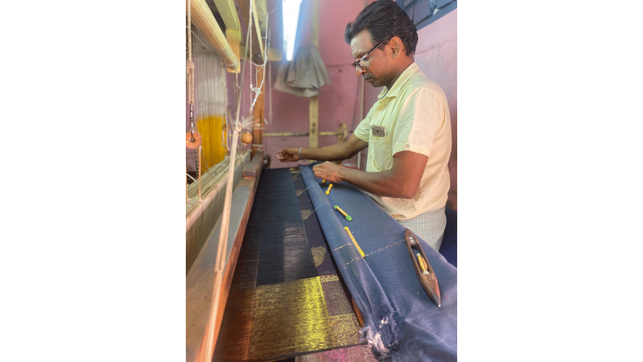 <div class="paragraphs"><p>Yeri Swamy working on the 'shot effect' of Molakalmuru saris, where the body is woven with black warp and purple weft.</p></div>