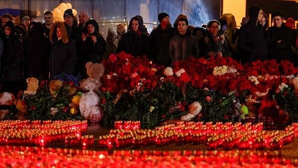 <div class="paragraphs"><p>People stand in front of lit candles outside the Crocus City Hall concert venue on the day of mourning declared following a deadly shooting, in the Moscow Region, Russia.</p></div>