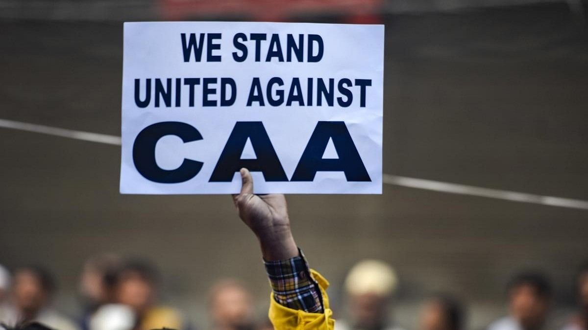 <div class="paragraphs"><p> A protestor holds a placard during a demonstration against the Citizenship Amendment Act (CAA).</p></div>