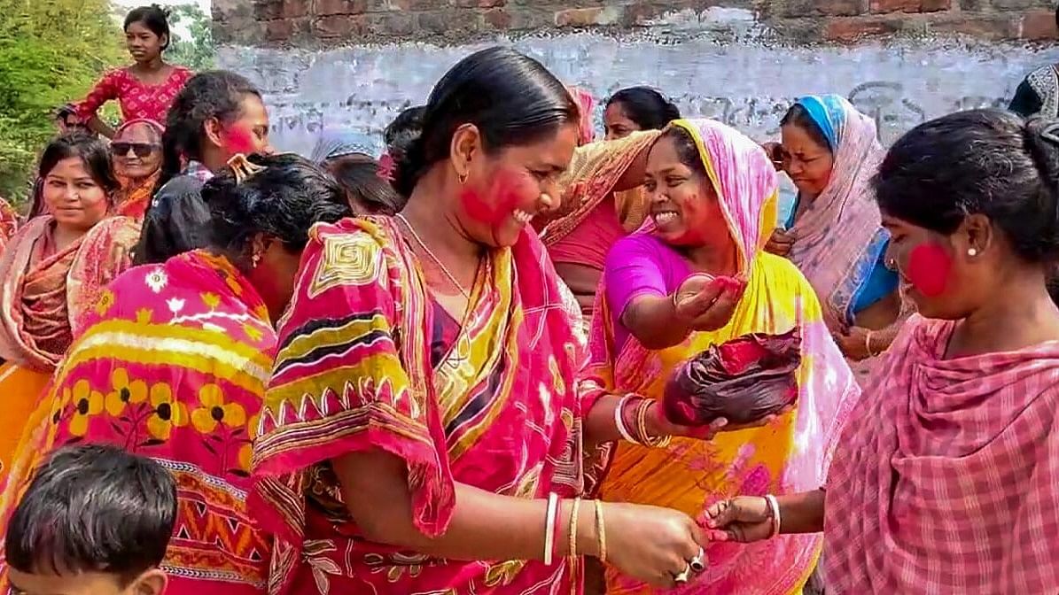 <div class="paragraphs"><p>Villagers celebrate with coloured powder (Gulal) after the arrest of TMC leader Sheikh Shahjahan, accused of sexual violence and land grabbing at Sandeshkhali village.</p></div>