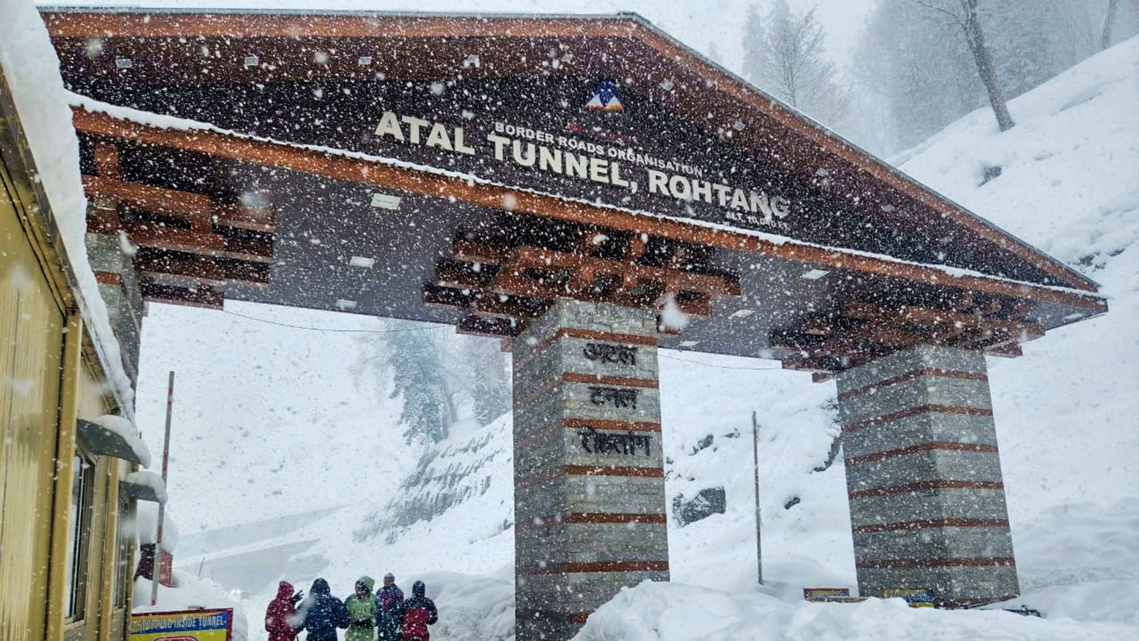 <div class="paragraphs"><p>Tourists pose for photos amid snowfall at the south portal of the Atal Tunnel, in Manali.</p></div>