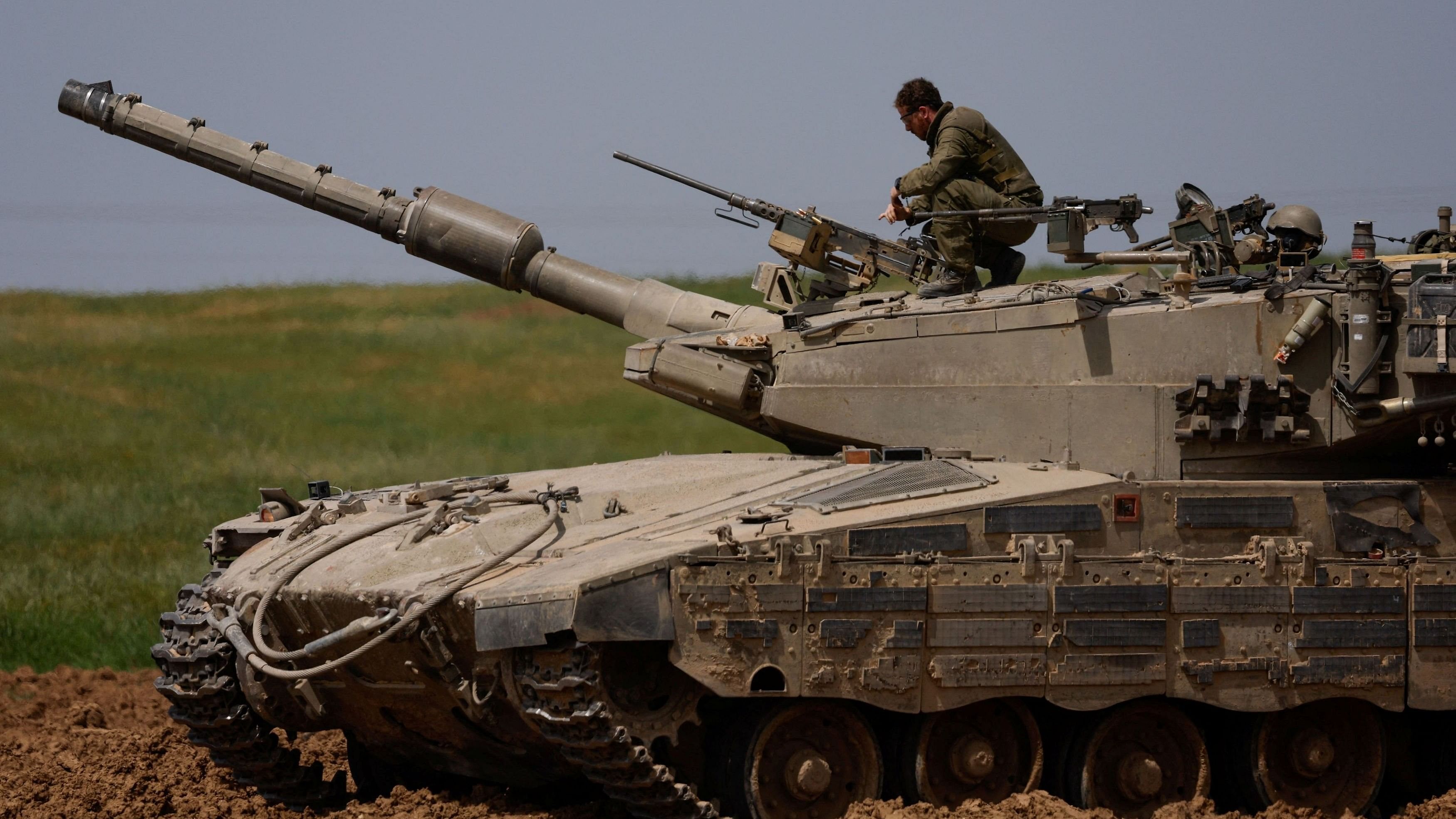 <div class="paragraphs"><p>An Israeli soldier unloads a weapon on top of a tank.</p></div>