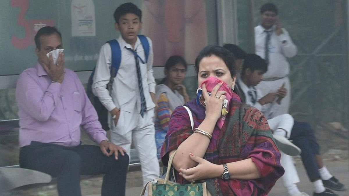 <div class="paragraphs"><p>People use handkerchiefs to protect themselves from heavy smog and air pollution that reached hazardous levels, at a bus stop in New Delhi.</p></div>