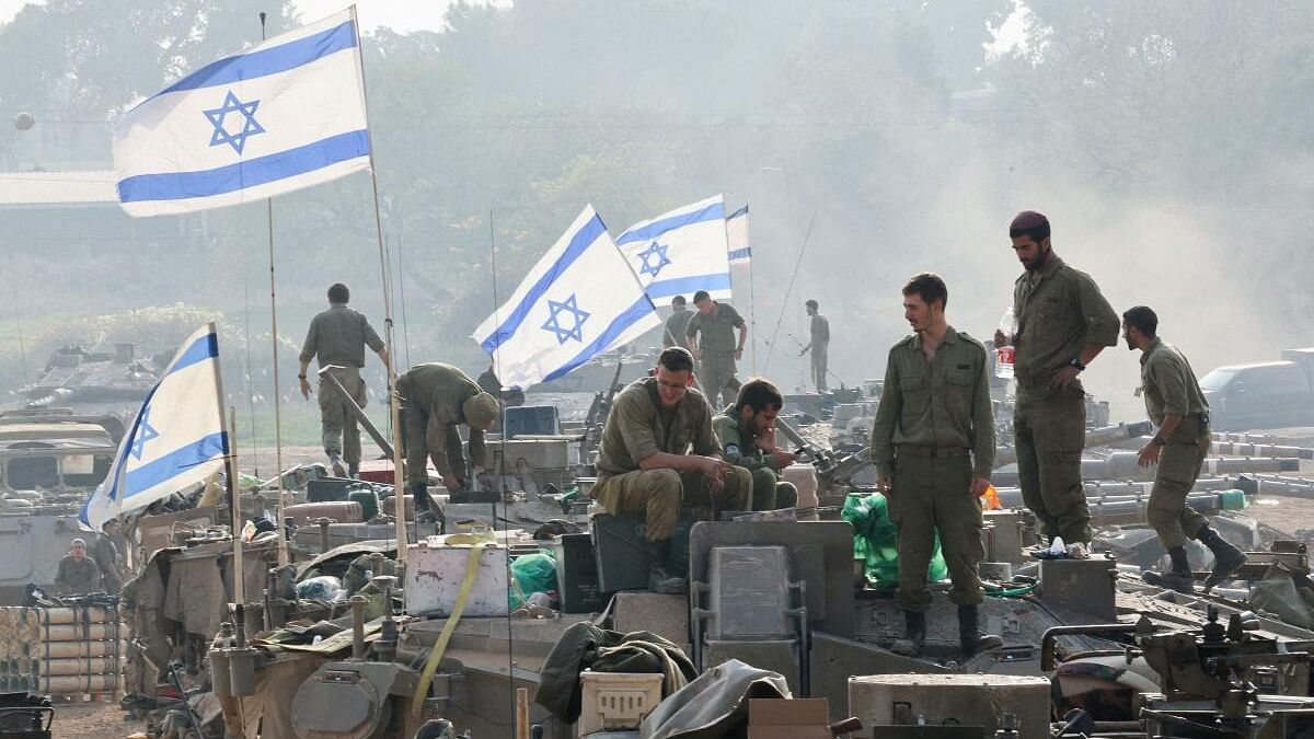 <div class="paragraphs"><p> Israeli soldiers stand on tanks, amid the ongoing conflict </p></div>