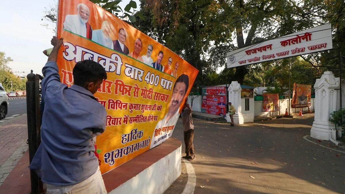 <div class="paragraphs"><p>Workers remove political banners after the Model Code of Conduct was enforced following the announcement of the schedule of Lok Sabha elections, in Lucknow</p></div>