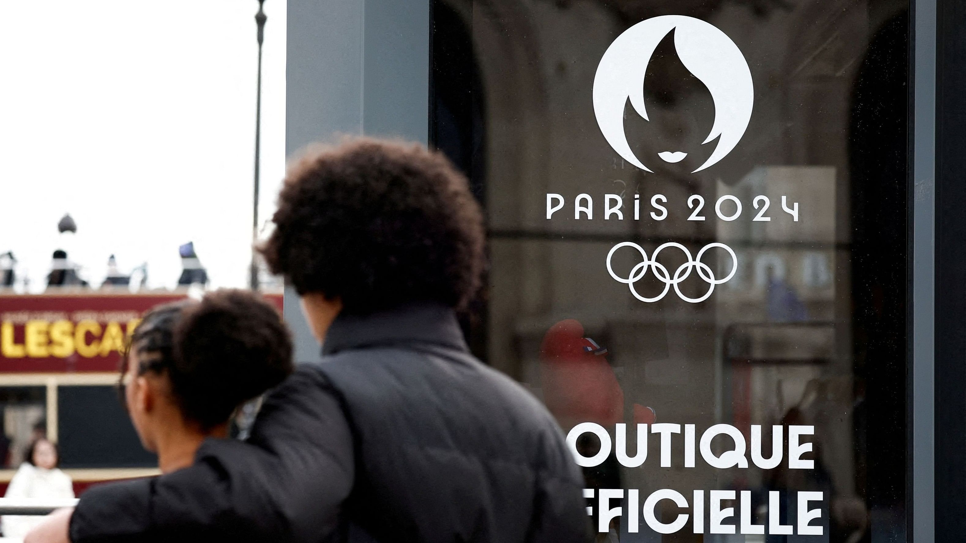 <div class="paragraphs"><p> People walk near the logo of the Paris 2024 Olympic and Paralympic Games on an official Paris 2024 store at Place de l'Opera in Paris, France</p></div>