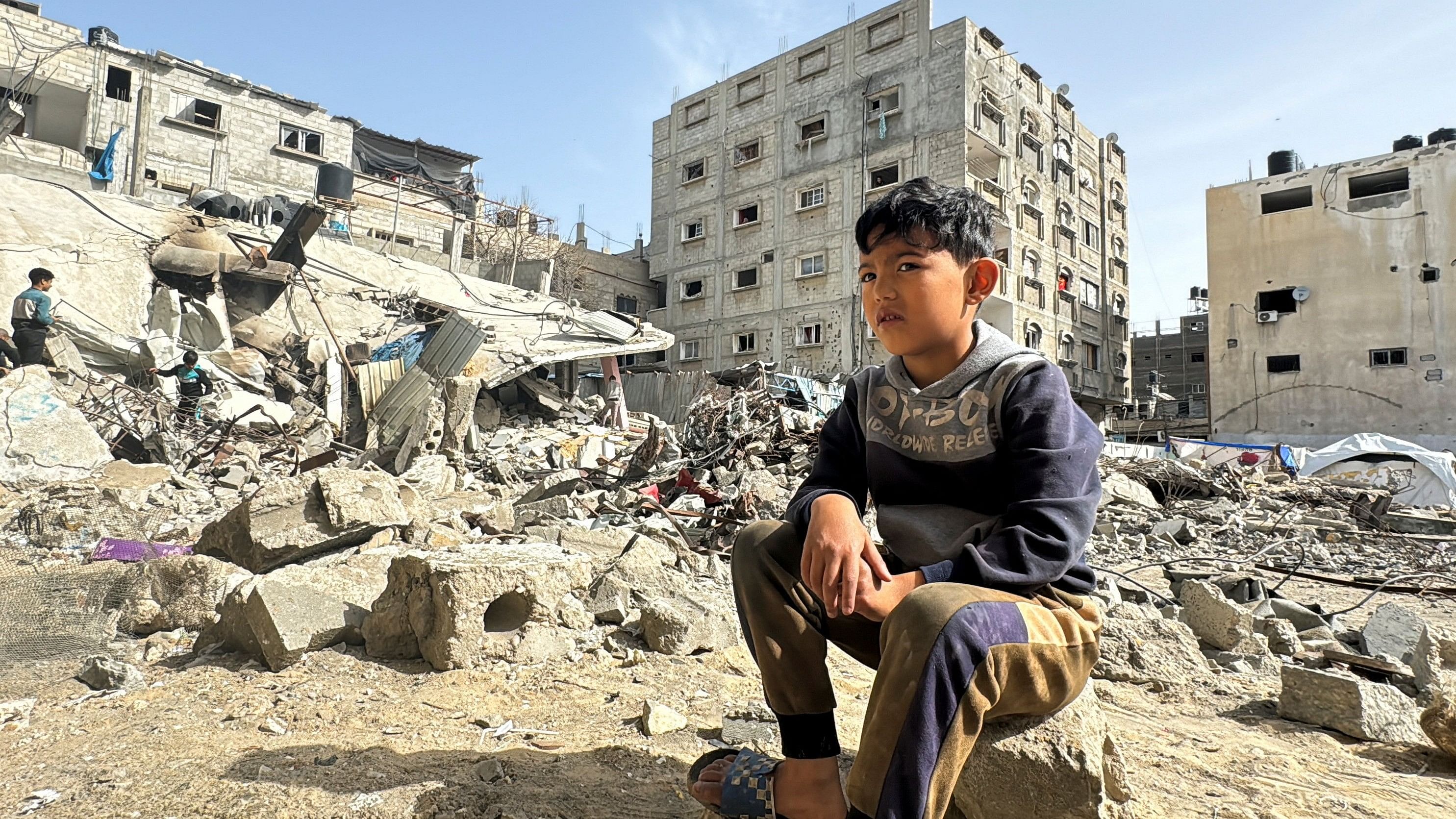 <div class="paragraphs"><p>A Palestinian boy sits on the site of an Israeli strike, amid the ongoing conflict between Israel and the Palestinian Islamist group Hamas, in Rafah.&nbsp;</p></div>